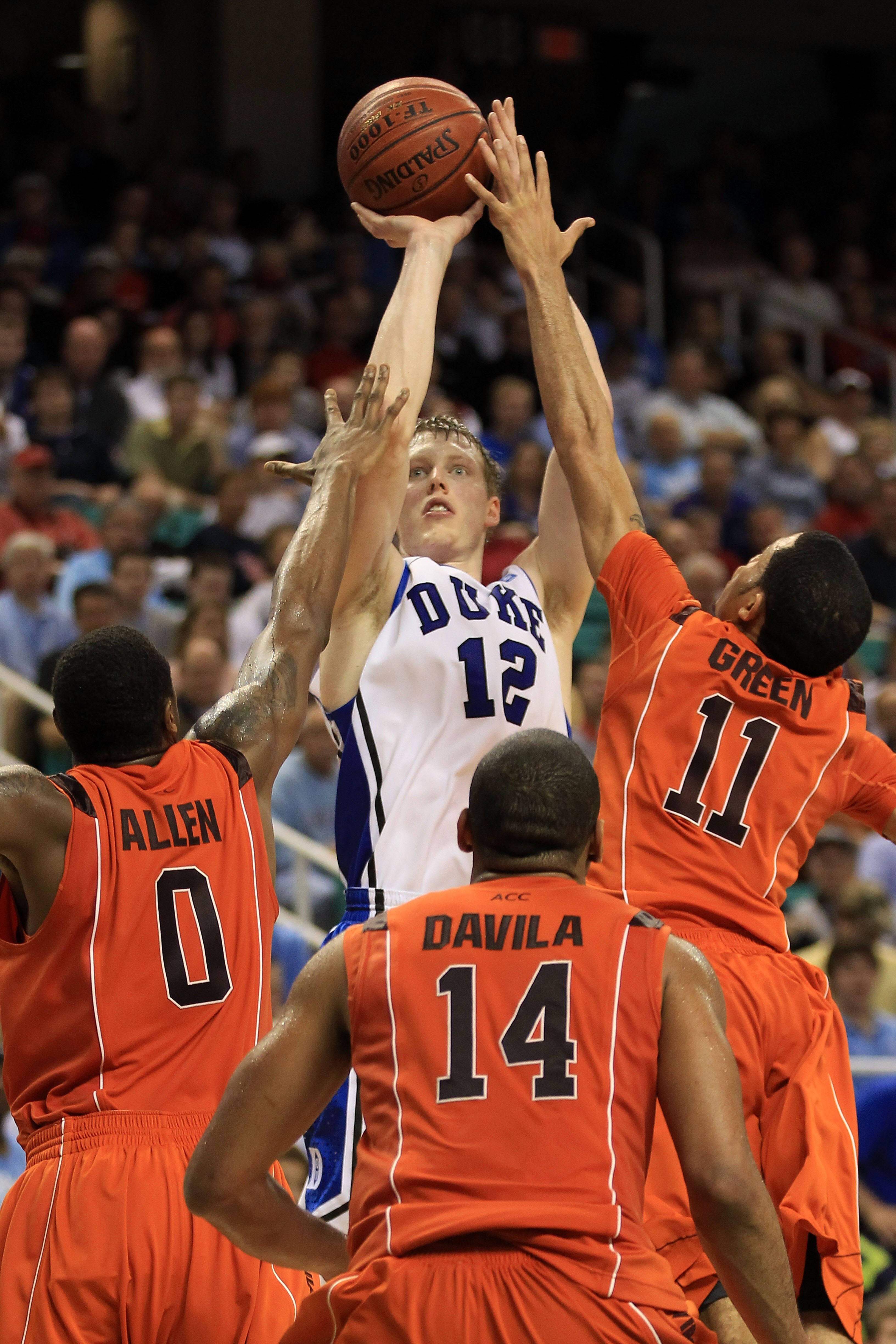 GREENSBORO, NC - MARCH 12:  Kyle Singler #12 of the Duke Blue Devils shoots against Jeff Allen #0, Victor Davila #14 and Erick Green #11 of the Virginia Tech Hokies during the first half in the semifinals of the 2011 ACC men's basketball tournament at the