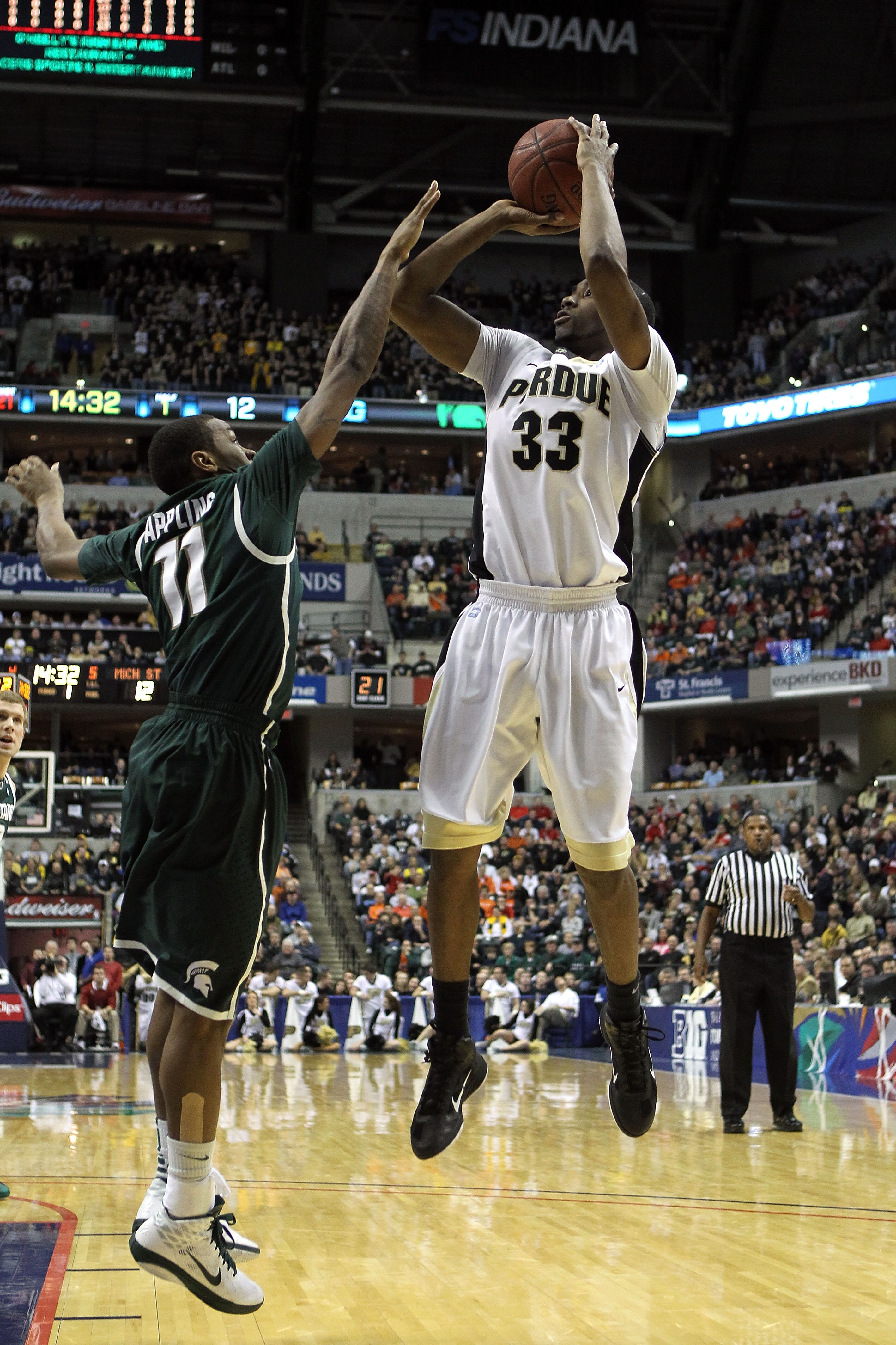 INDIANAPOLIS, IN - MARCH 11:  E'Twaun Moore #33 of the Purdue Boilermakers attempts a shot against Keith Appling #11 of the Michigan State Spartans during the quarterfinals of the 2011 Big Ten Men's Basketball Tournament at Conseco Fieldhouse on March 11,