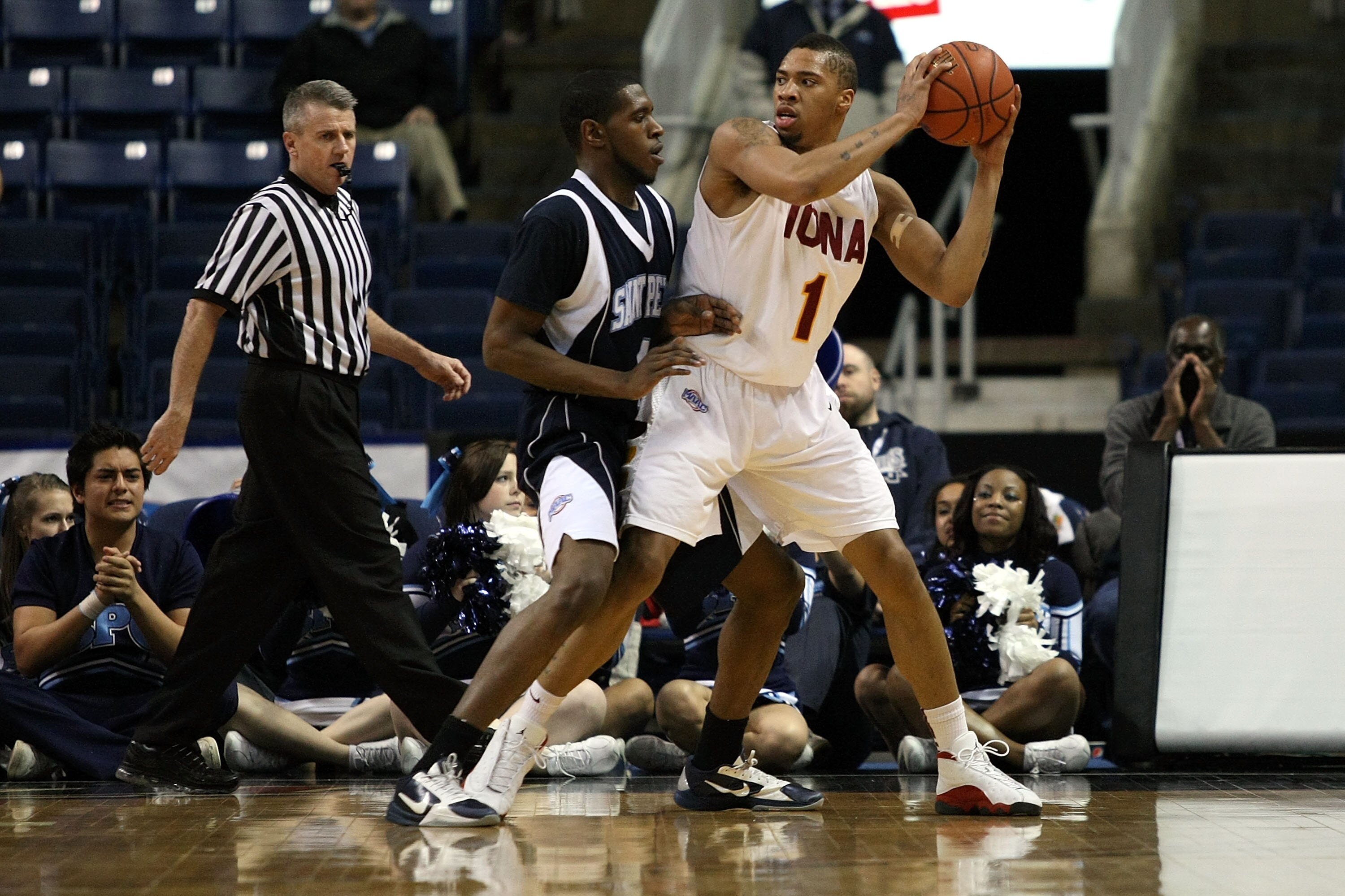 BRIDGEPORT, CT - MARCH 07: Michael Glover #1 of the Iona Gaels looks to pass as he is defended by Ryan Bacon #4 of the St. Peter's Peacocks during the final of the MAAC men's conference basketball tournment at Webster Bank Arena at Harbor Yard on March 7 BRIDGEPORT, CT - MARCH 07: Michael Glover #1 of the Iona Gaels looks to pass as he is defended by Ryan Bacon #4 of the St. Peter's Peacocks during the final of the MAAC men's conference basketball tournment at Webster Bank Arena at Harbor Yard on March 7