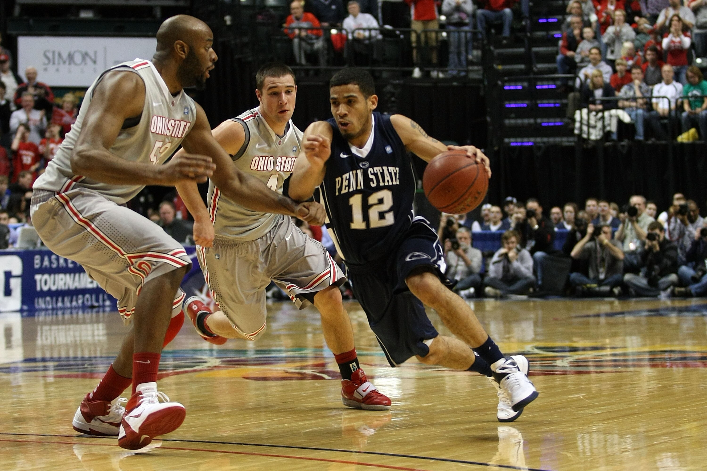 INDIANAPOLIS, IN - MARCH 13: Talor Battle #12 of the Penn State Nittany Lions drives against Dallas Lauderdale #52 and Aaron Craft #4 of the Ohio State Buckeyes during the championship game of the 2011 Big Ten Men's Basketball Tournament at Conseco Field INDIANAPOLIS, IN - MARCH 13: Talor Battle #12 of the Penn State Nittany Lions drives against Dallas Lauderdale #52 and Aaron Craft #4 of the Ohio State Buckeyes during the championship game of the 2011 Big Ten Men's Basketball Tournament at Conseco Field