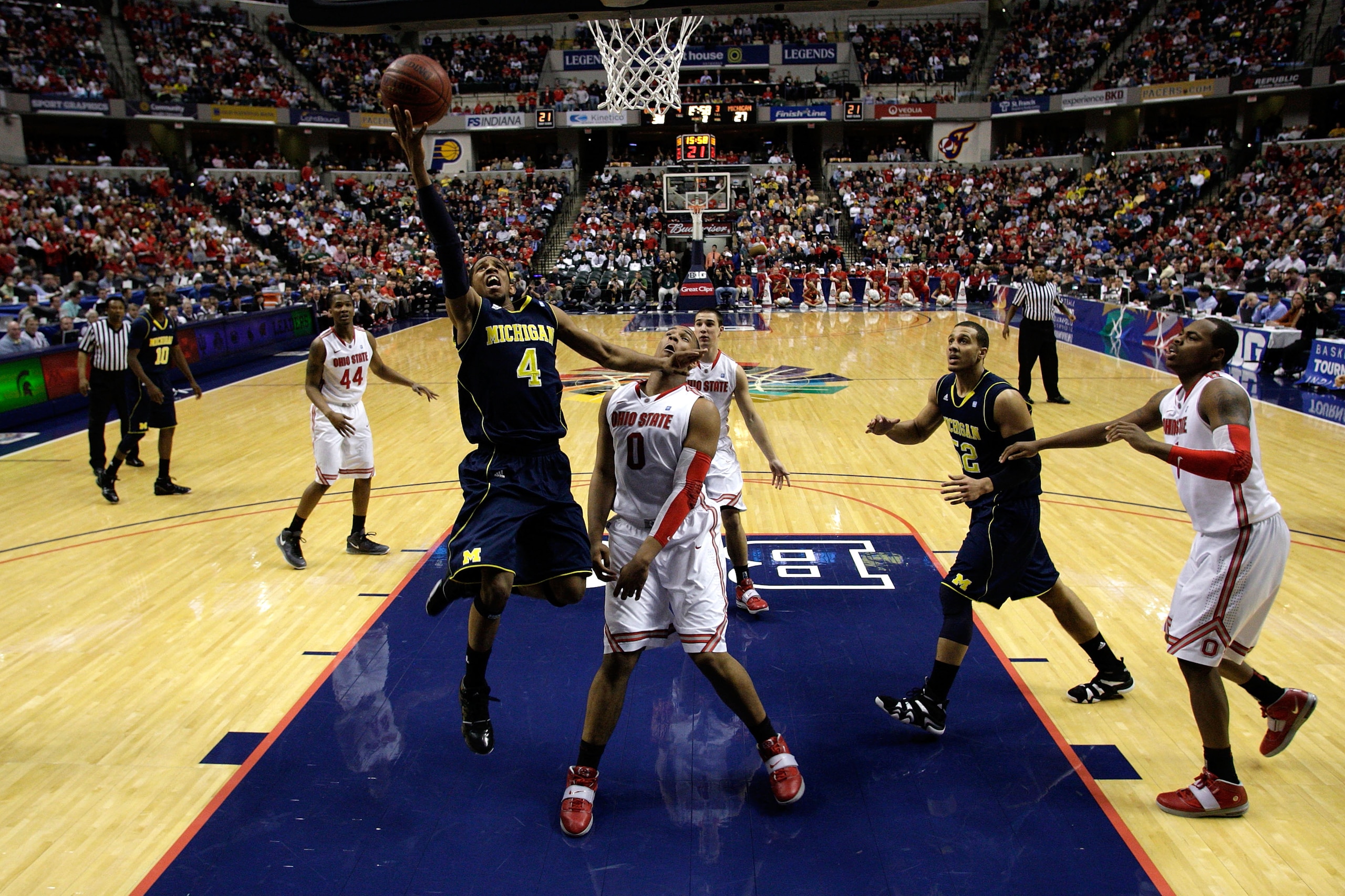 INDIANAPOLIS, IN - MARCH 12:  Darius Morris #4 of the Michigan Wolverines attempts a shot against Jared Sullinger #0 of the Ohio State Buckeyes during the semifinals of the 2011 Big Ten Men's Basketball Tournament at Conseco Fieldhouse on March 12, 2011 i