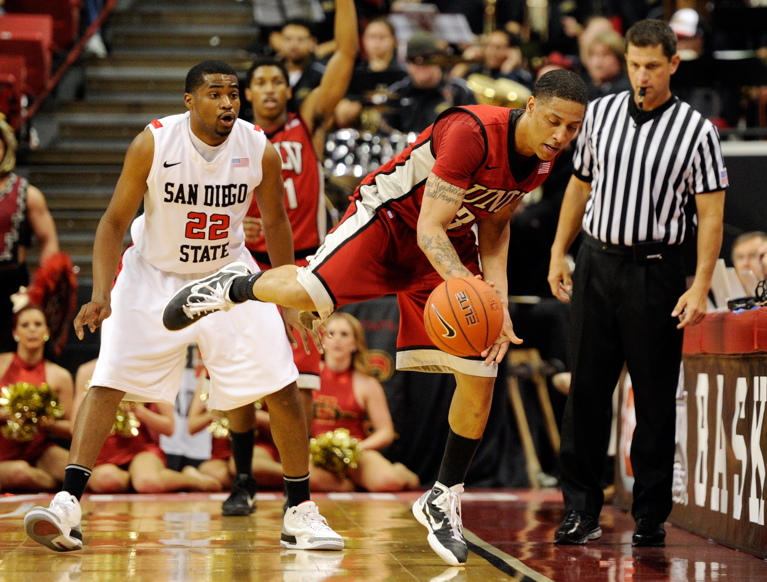LAS VEGAS, NV - MARCH 11: Tre'Von Willis #33 of the UNLV Rebels saves the ball from going out of bounds as Chase Tapley #22 of the San Diego State Aztecs looks on during a semifinal game of the Conoco Mountain West Conference Basketball tournament at the LAS VEGAS, NV - MARCH 11: Tre'Von Willis #33 of the UNLV Rebels saves the ball from going out of bounds as Chase Tapley #22 of the San Diego State Aztecs looks on during a semifinal game of the Conoco Mountain West Conference Basketball tournament at the