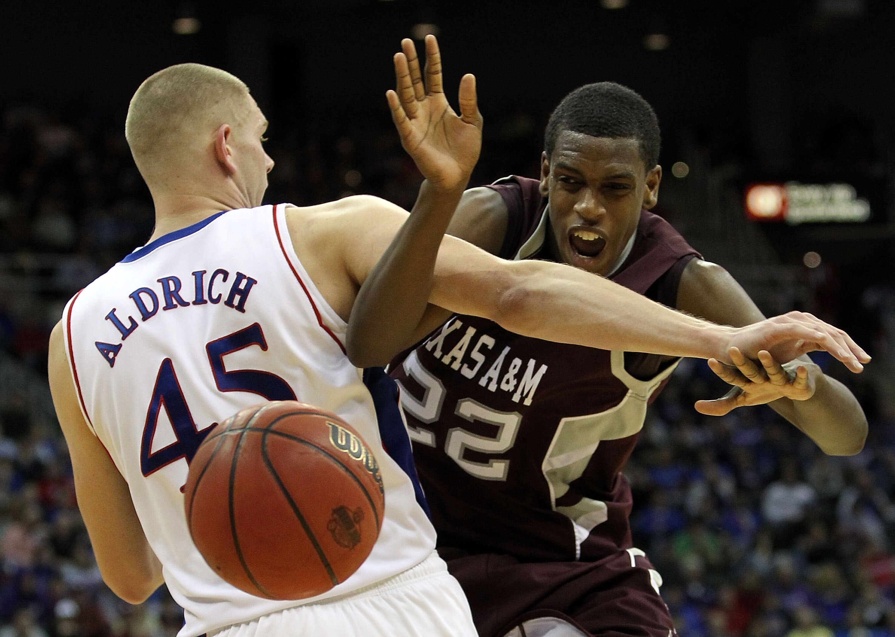KANSAS CITY, MO - MARCH 12: Khris Middleton #22 of the Texas A&M Aggies is fouled by Cole Aldrich #45 of the Kansas Jayhawks during the semifinals of the 2010 Phillips 66 Big 12 Men's Basketball Tournament at the Sprint Center on March 12, 2010 in Kansas KANSAS CITY, MO - MARCH 12: Khris Middleton #22 of the Texas A&M Aggies is fouled by Cole Aldrich #45 of the Kansas Jayhawks during the semifinals of the 2010 Phillips 66 Big 12 Men's Basketball Tournament at the Sprint Center on March 12, 2010 in Kansas