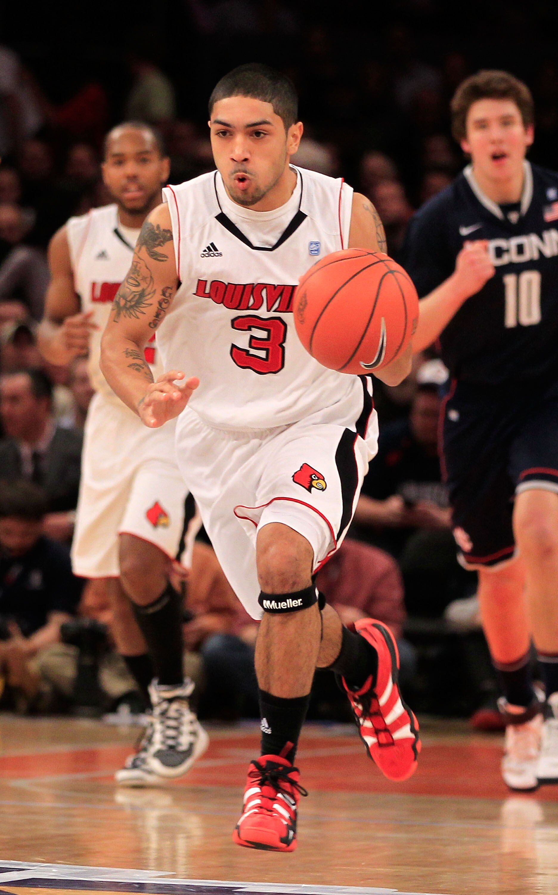 NEW YORK, NY - MARCH 12:  Peyton Siva #3 of the Louisville Cardinals brings the ball up court against the Connecticut Huskies during the championship of the 2011 Big East Men's Basketball Tournament presented by American Eagle Outfitters at Madison Square