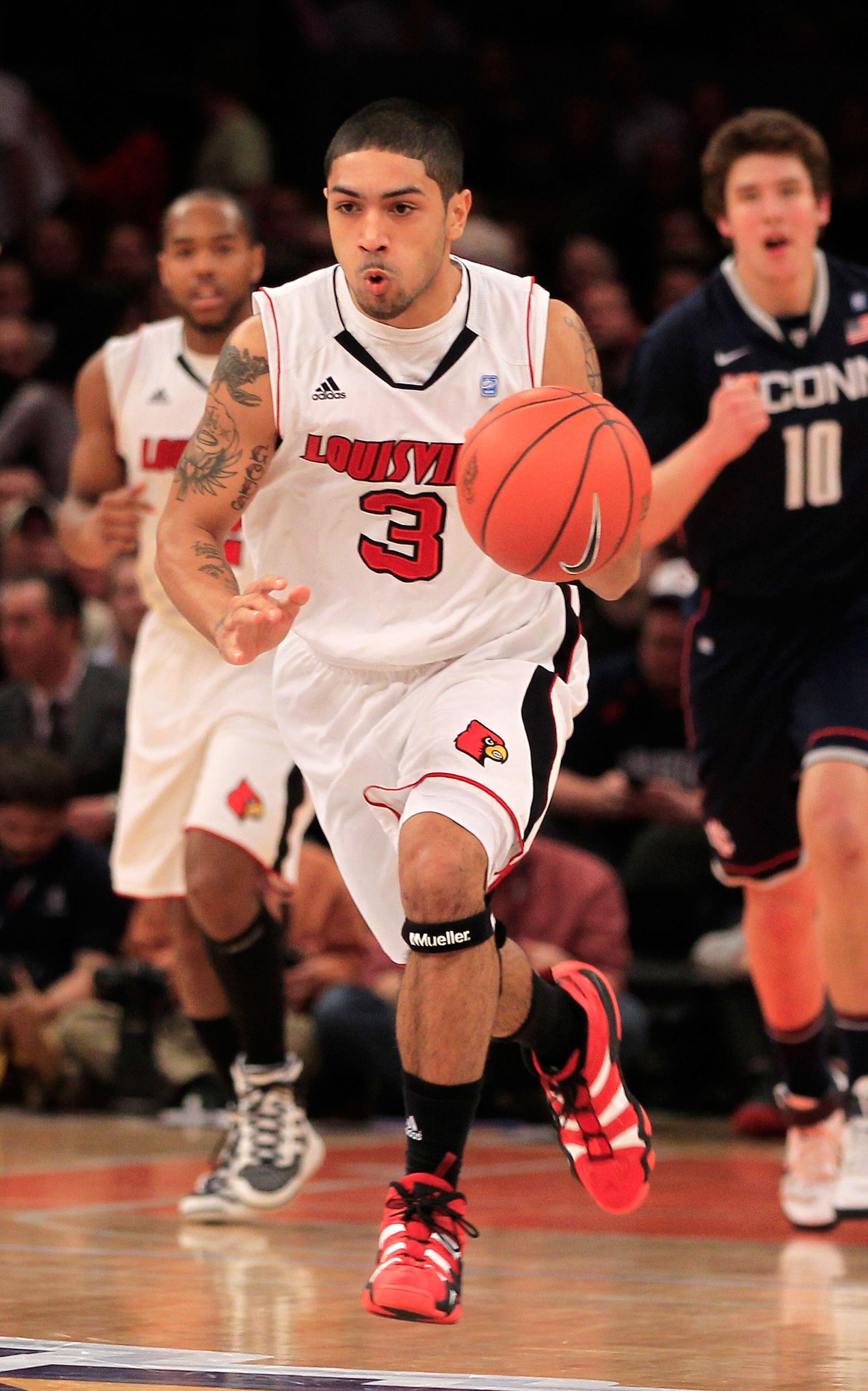 NEW YORK, NY - MARCH 12:  Peyton Siva #3 of the Louisville Cardinals brings the ball up court against the Connecticut Huskies during the championship of the 2011 Big East Men's Basketball Tournament presented by American Eagle Outfitters at Madison Square