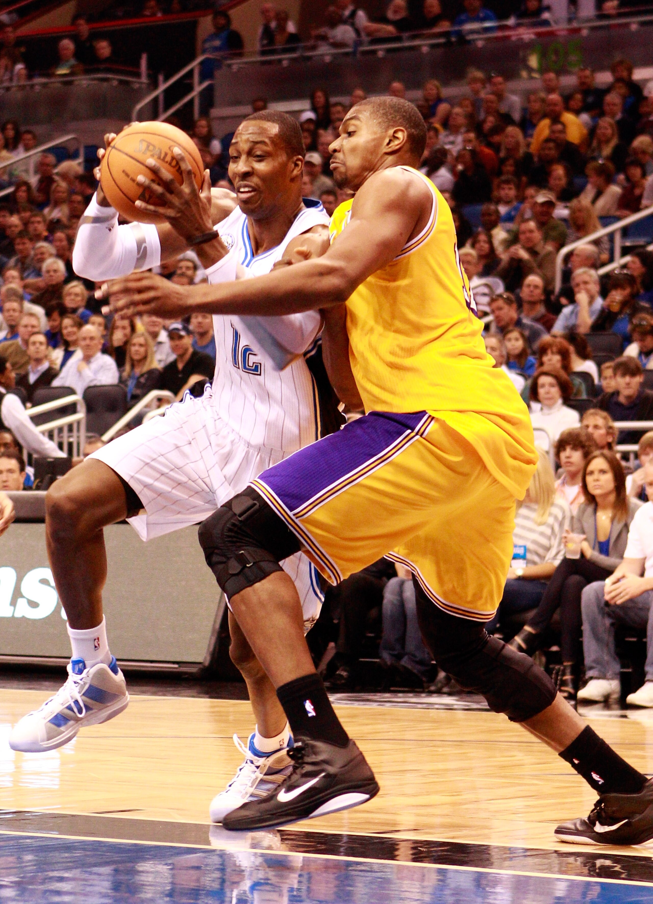 ORLANDO, FL - FEBRUARY 13: Dwight Howard #12 of the Orlando Magic drives against Andrew Bynum #17 of the Los Angeles Lakers during the game at Amway Arena on February 13, 2011 in Orlando, Florida. NOTE TO USER: User expressly acknowledges and agrees tha ORLANDO, FL - FEBRUARY 13: Dwight Howard #12 of the Orlando Magic drives against Andrew Bynum #17 of the Los Angeles Lakers during the game at Amway Arena on February 13, 2011 in Orlando, Florida. NOTE TO USER: User expressly acknowledges and agrees tha