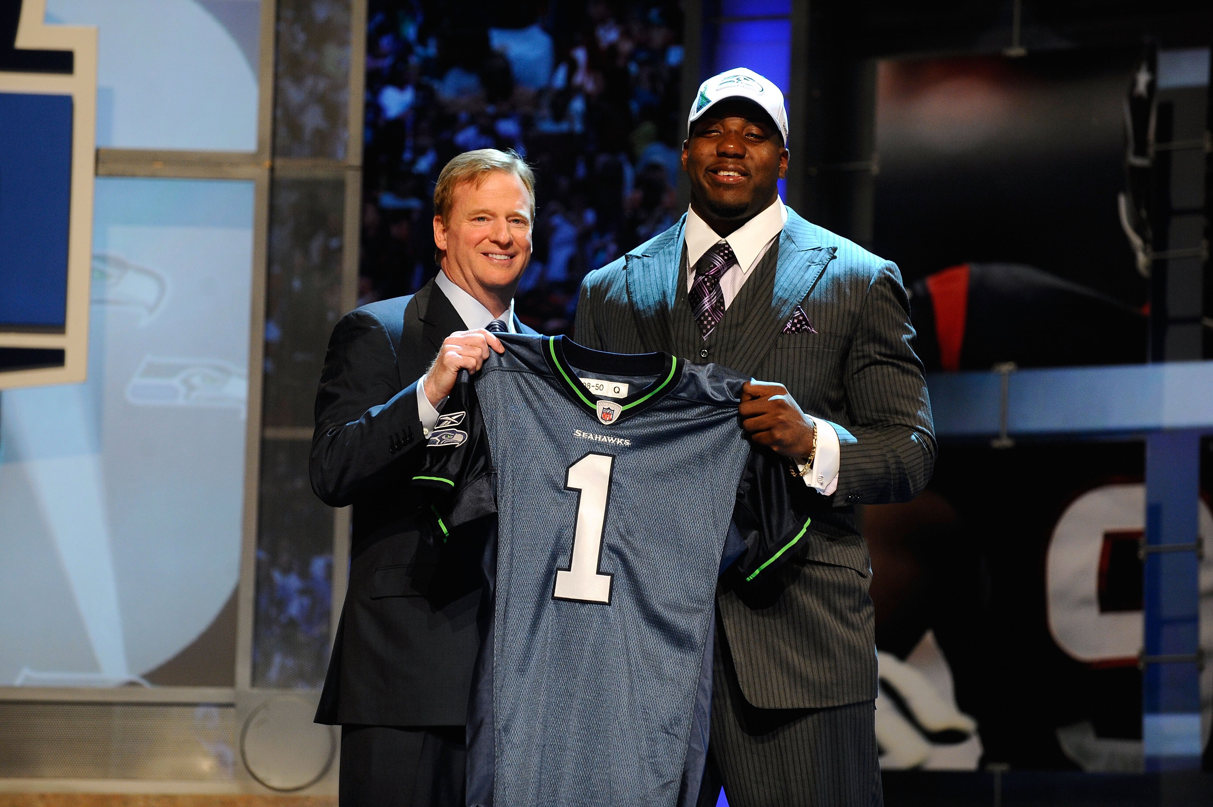 NEW YORK - APRIL 22:  Russell Okung from the Oklahoma State Cowboys poses with NFL Commissioner Roger Goodell (L) as they hold a Seattle Seahawks jersey after Okung was selected number 6 overall by the Seahawks in the first round during the 2010 NFL Draft
