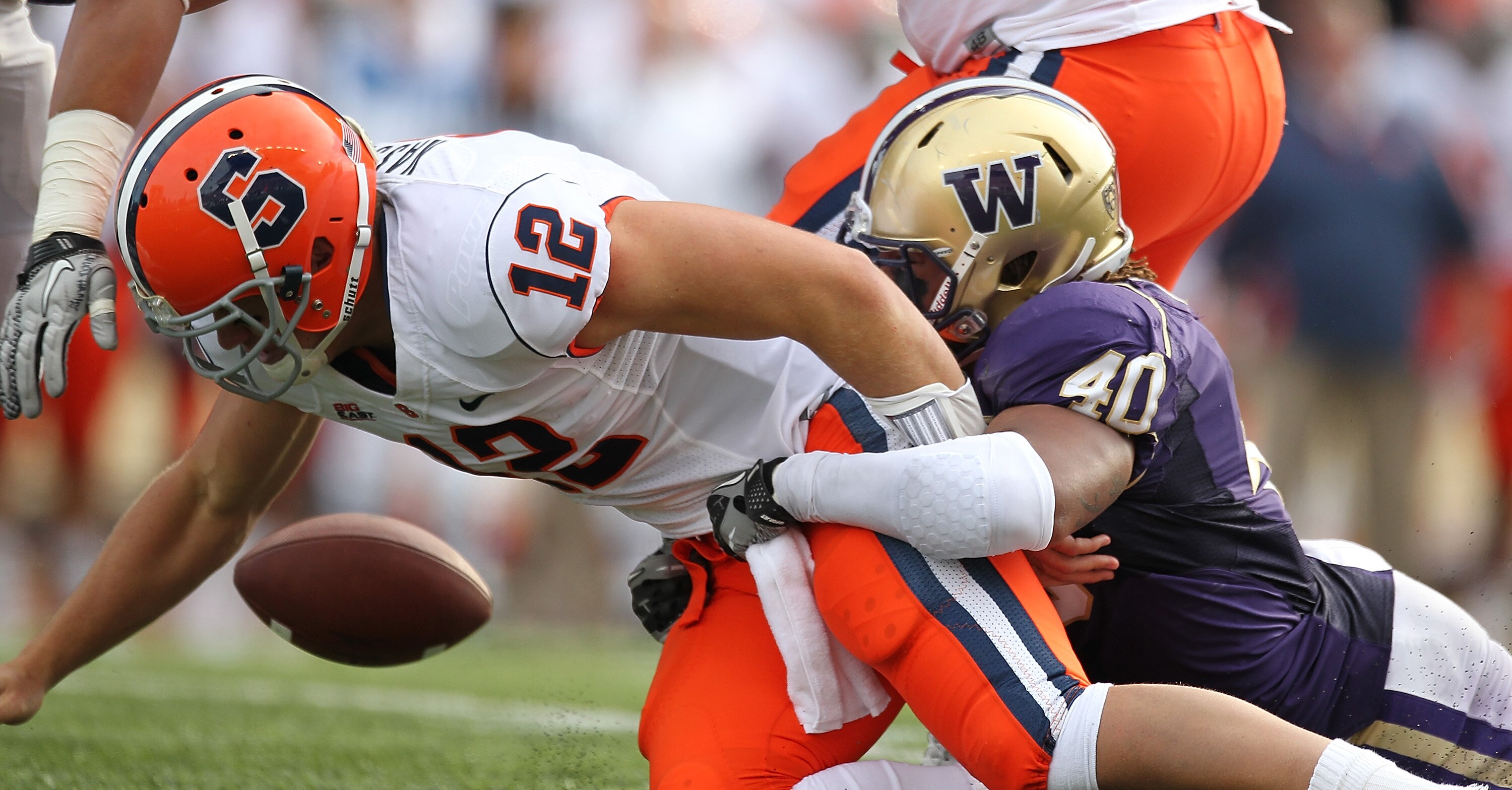 SEATTLE - SEPTEMBER 11:  Quarterback Ryan Nassib #12 of the Syracuse Orange fumbles the ball against Mason Foster #40 of the Washington Huskies on September 11, 2010 at Husky Stadium in Seattle, Washington. The Huskies defeated the Orange 41-20. (Photo by