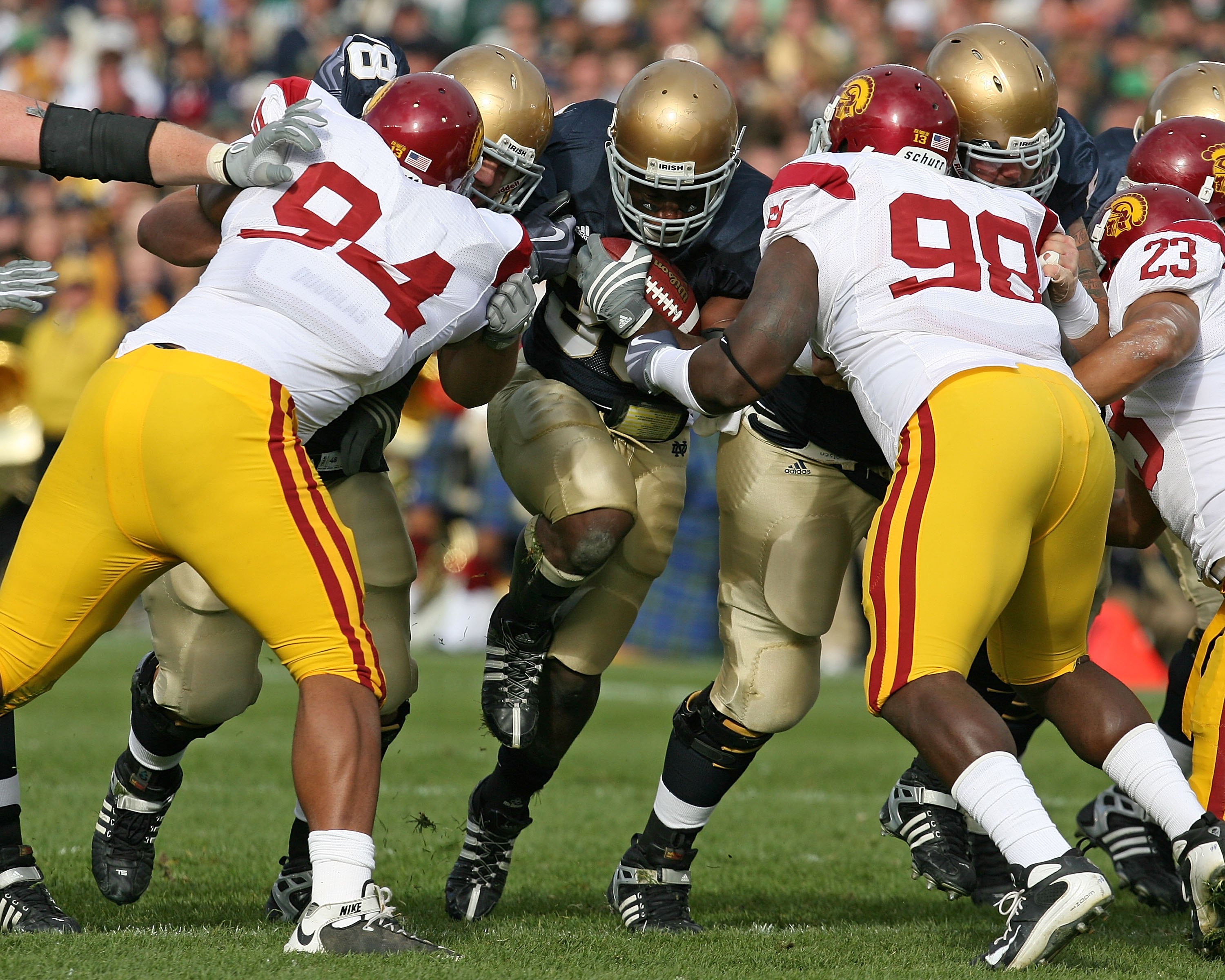 SOUTH BEND, IN - OCTOBER 17: Robert Hughes #33 of the Notre Dame Fighting Irish looks for running run against Armond Armstead #94 and DaJohn Harris #98 of the USC Trojans at Notre Dame Stadium on October 17, 2009 in South Bend, Indiana. USC defeated Notre