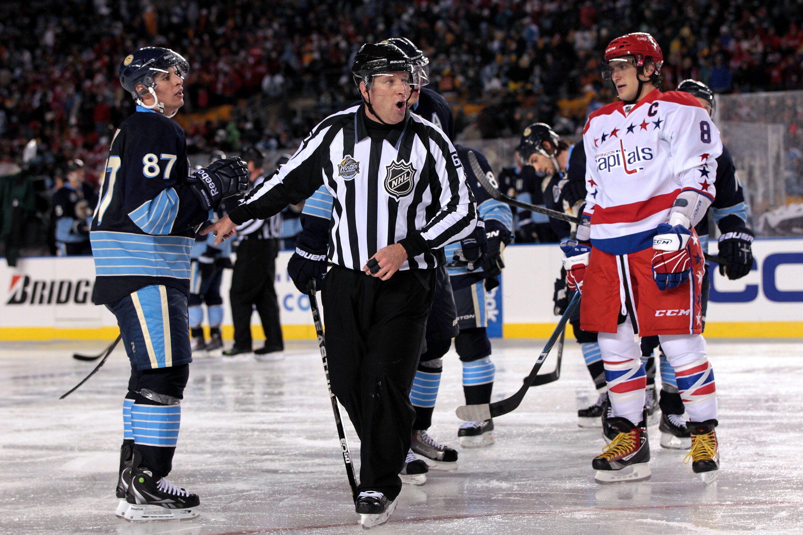PITTSBURGH, PA - JANUARY 01:  Alex Ovechkin #8 of the Washington Capitals and Sidney Crosby #81 of the Pittsburgh Penguins are seperated by a referee during the 2011 NHL Bridgestone Winter Classic at Heinz Field on January 1, 2011 in Pittsburgh, Pennsylva