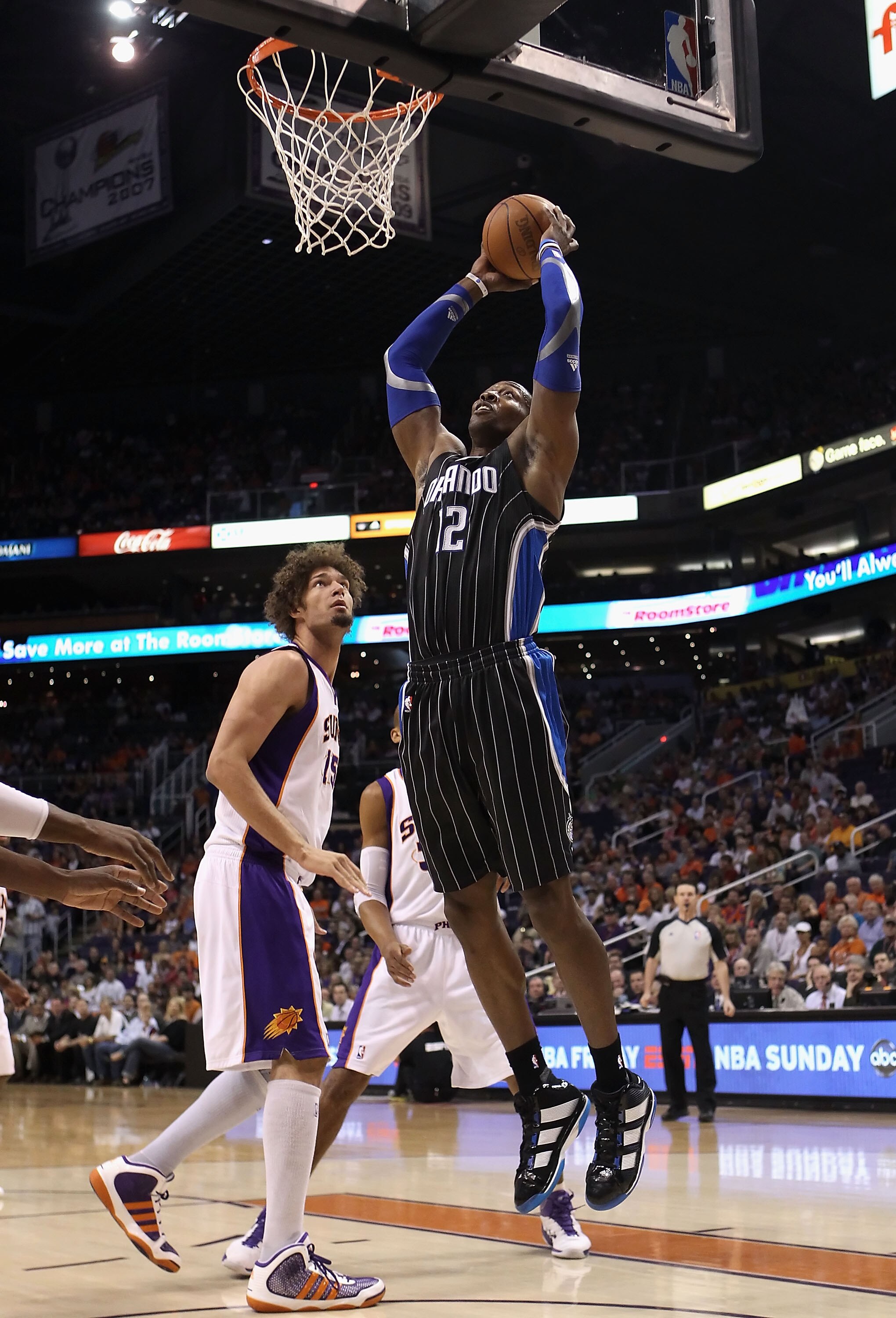 PHOENIX, AZ - MARCH 13: Dwight Howard #12 of the Orlando Magic slam dunks the ball over Robin Lopez #15 of the Phoenix Suns during the NBA game at US Airways Center on March 13, 2011 in Phoenix, Arizona. NOTE TO USER: User expressly acknowledges and agr PHOENIX, AZ - MARCH 13: Dwight Howard #12 of the Orlando Magic slam dunks the ball over Robin Lopez #15 of the Phoenix Suns during the NBA game at US Airways Center on March 13, 2011 in Phoenix, Arizona. NOTE TO USER: User expressly acknowledges and agr