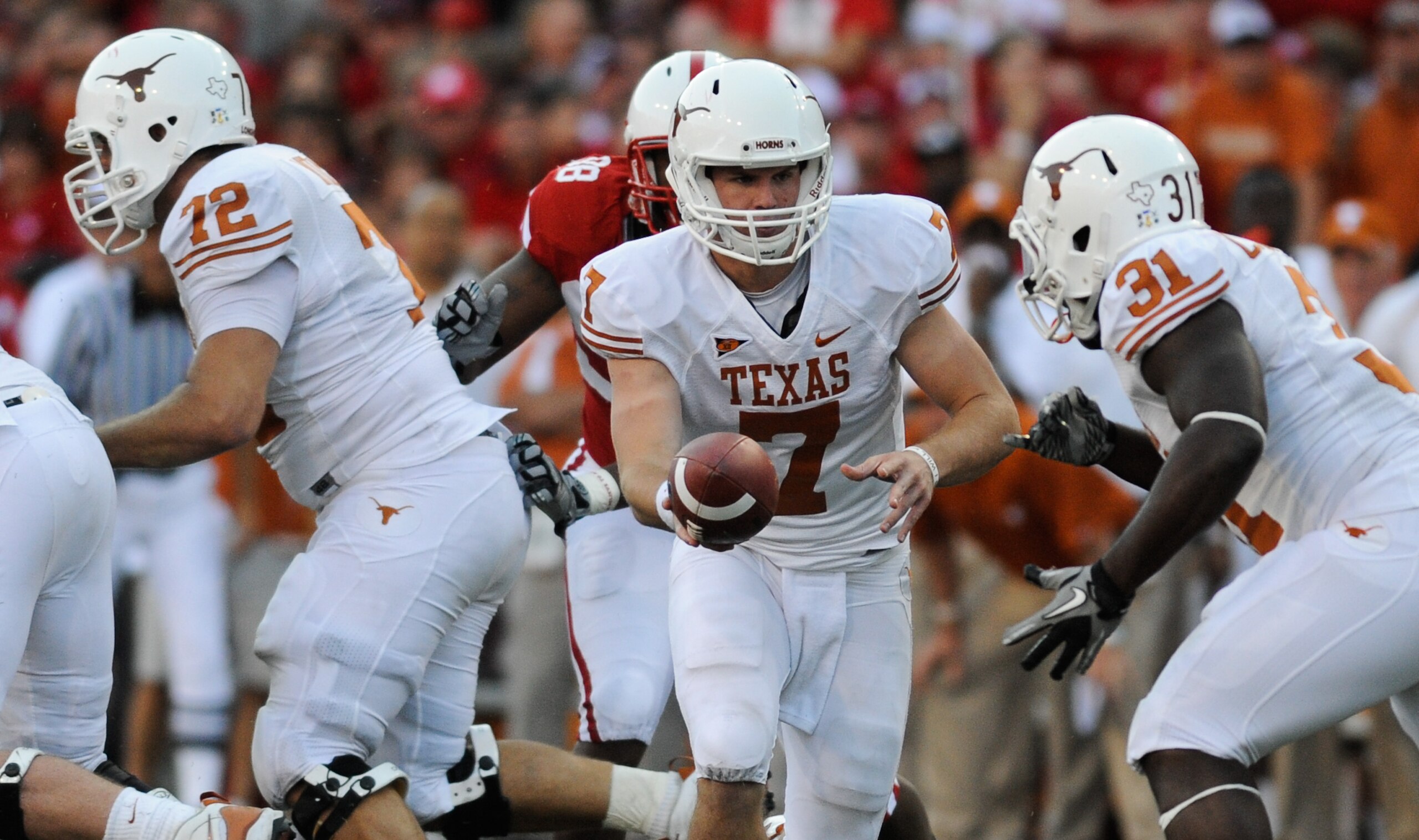 LINCOLN, NE - OCTOBER 16: Quarterback Garrett Gilbert #7 of the Texas Longhorns hand the ball to teammate running back Cody Johnson #31 during second half action of their game at Memorial Stadium on October 16, 2010 in Lincoln, Nebraska. Texas Defeated Ne LINCOLN, NE - OCTOBER 16: Quarterback Garrett Gilbert #7 of the Texas Longhorns hand the ball to teammate running back Cody Johnson #31 during second half action of their game at Memorial Stadium on October 16, 2010 in Lincoln, Nebraska. Texas Defeated Ne