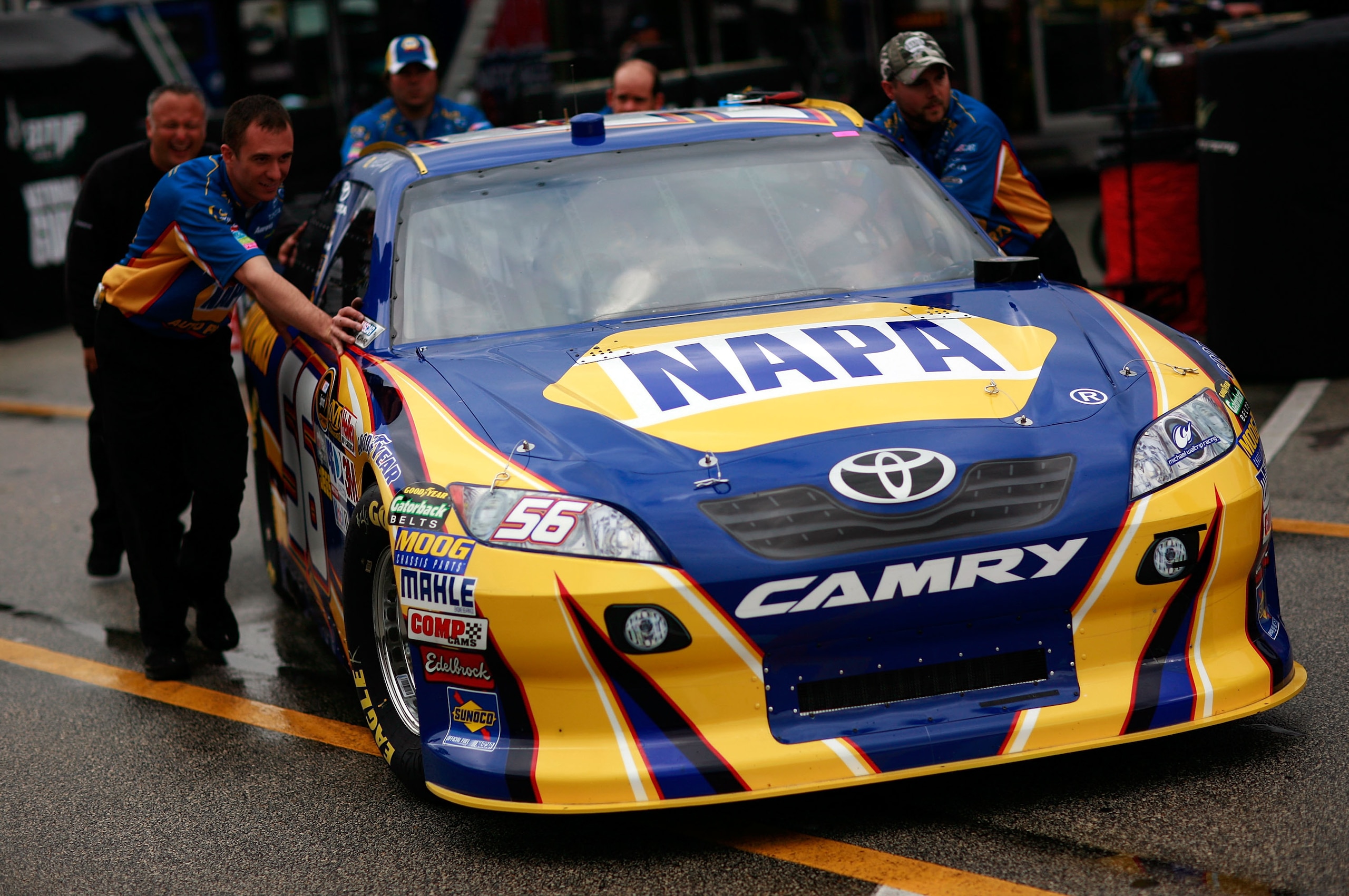 DAYTONA BEACH, FL - FEBRUARY 16:  Crew members push the #56 NAPA Toyota of Martin Truex Jr. during a rain delay in the garage area during practice for the NASCAR Nationwide Series DRIVE4COPD 300 at Daytona International Speedway February 16, 2011 in Dayto