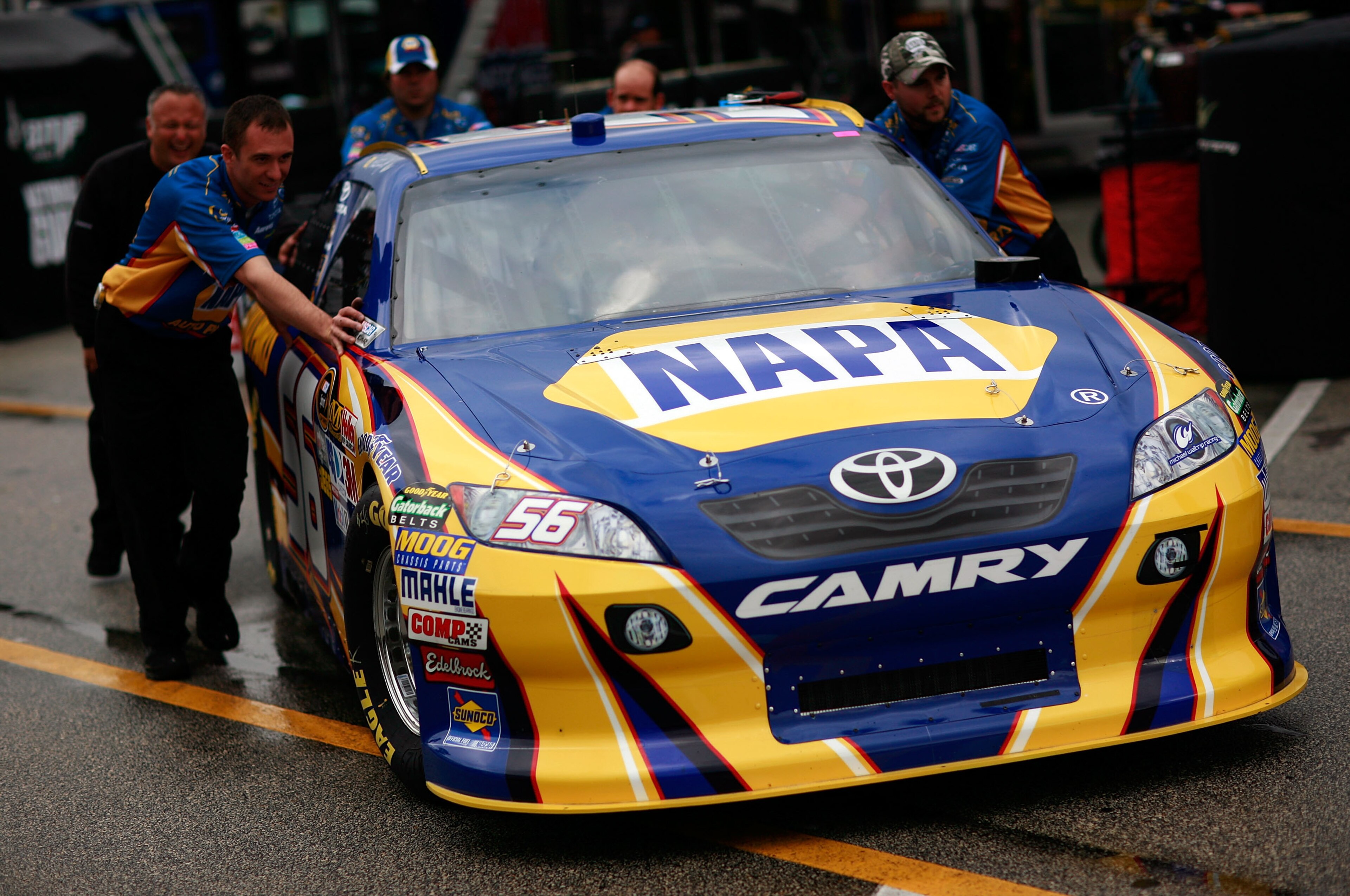 DAYTONA BEACH, FL - FEBRUARY 16:  Crew members push the #56 NAPA Toyota of Martin Truex Jr. during a rain delay in the garage area during practice for the NASCAR Nationwide Series DRIVE4COPD 300 at Daytona International Speedway February 16, 2011 in Dayto