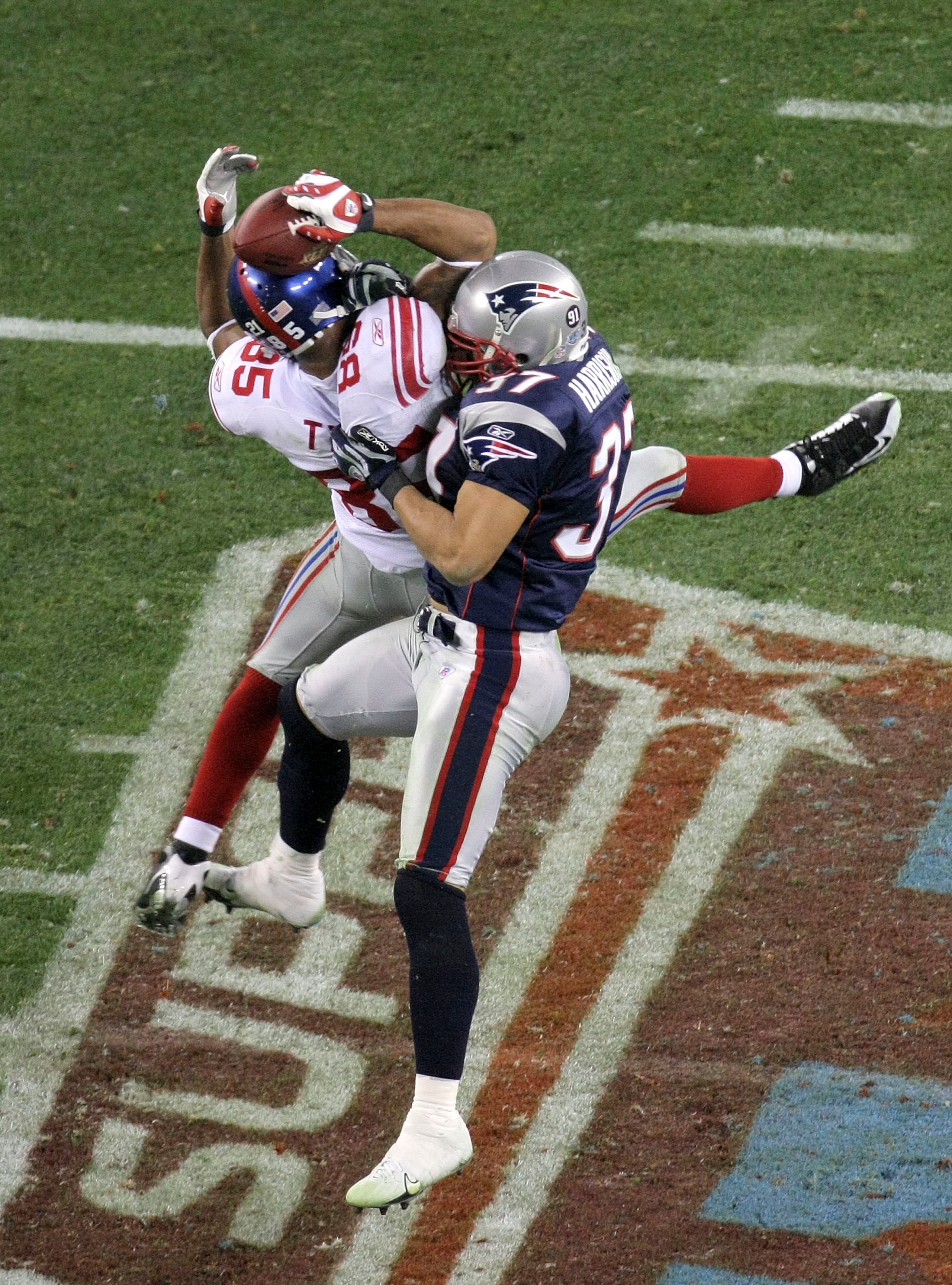 GLENDALE, AZ - FEBRUARY 03:  David Tyree #85 of the New York Giants catches a 32-yard pass from Eli Manning #10 as Rodney Harrison #37 of the New England Patriots attempts to knock it out in the fourth quarter of Super Bowl XLII on February 3, 2008 at the
