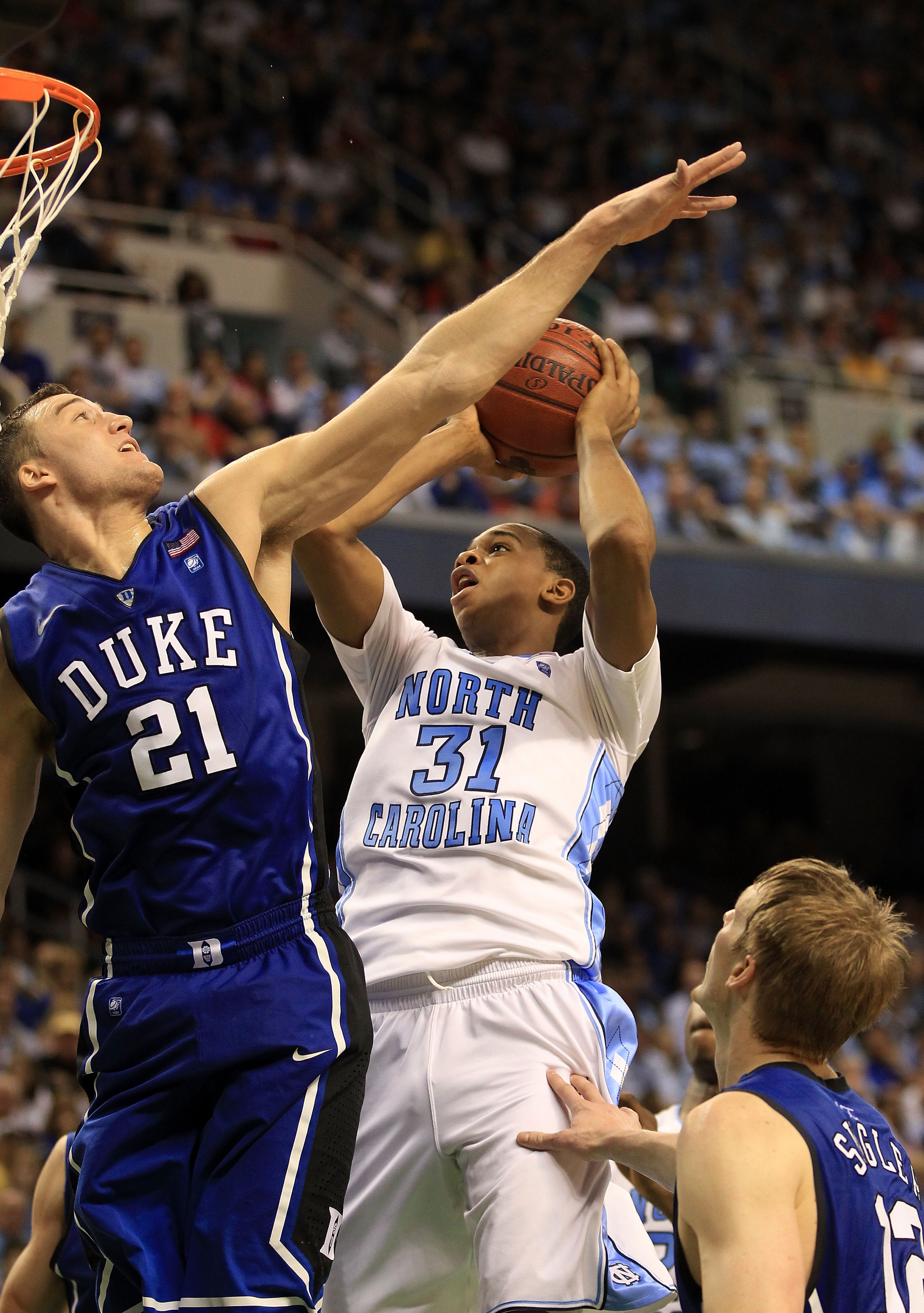 GREENSBORO, NC - MARCH 13:  John Henson #31 of the North Carolina Tar Heels shoots against Miles Plumlee #21 of the Duke Blue Devils during the second half in the championship game of the 2011 ACC men's basketball tournament at the Greensboro Coliseum on