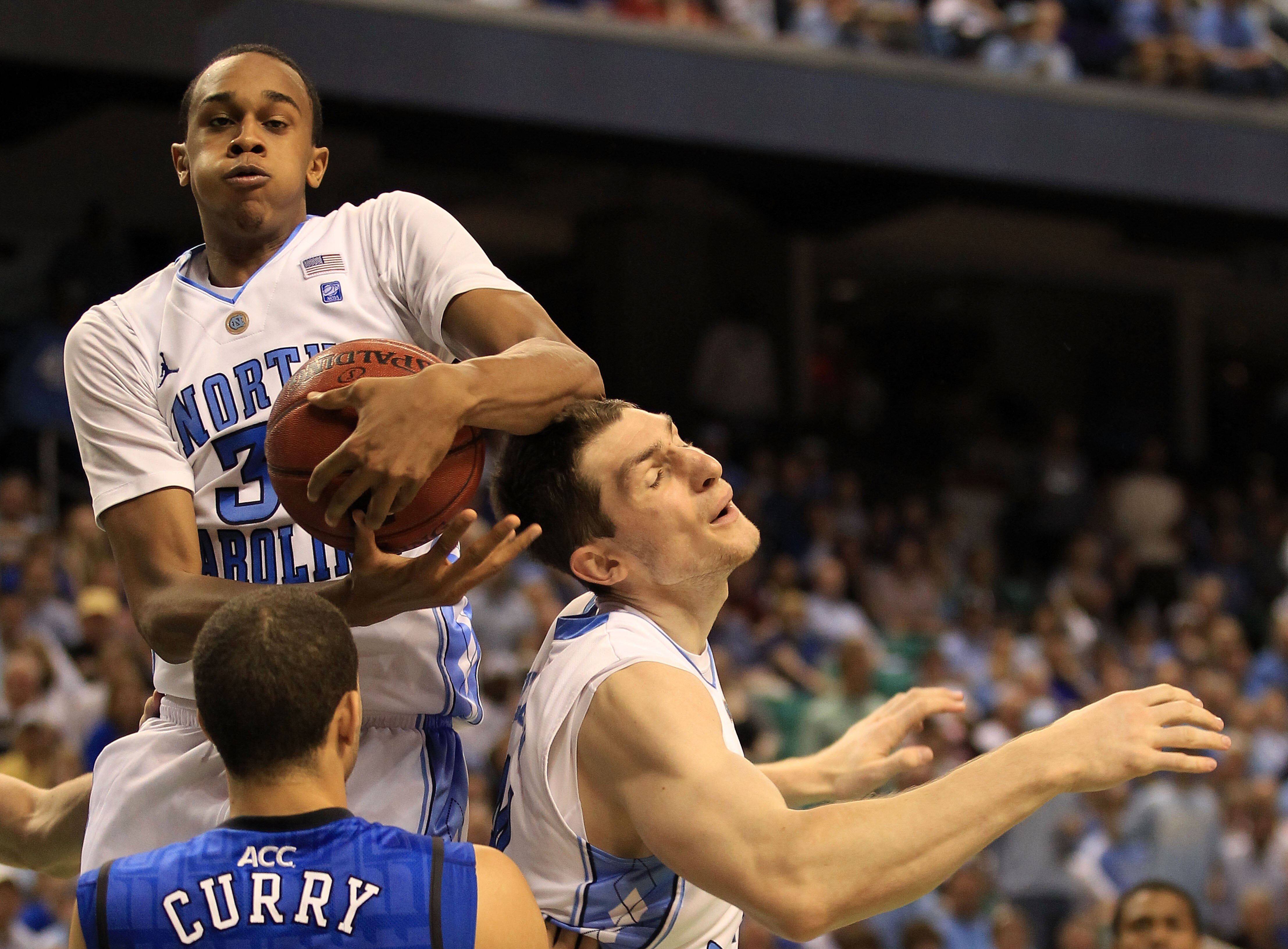 GREENSBORO, NC - MARCH 13:  John Henson #31 of the North Carolina Tar Heels rebounds a shot by teammate Tyler Zeller #44 as Seth Curry #30 of the Duke Blue Devils looks on during the second half in the championship game of the 2011 ACC men's basketball to