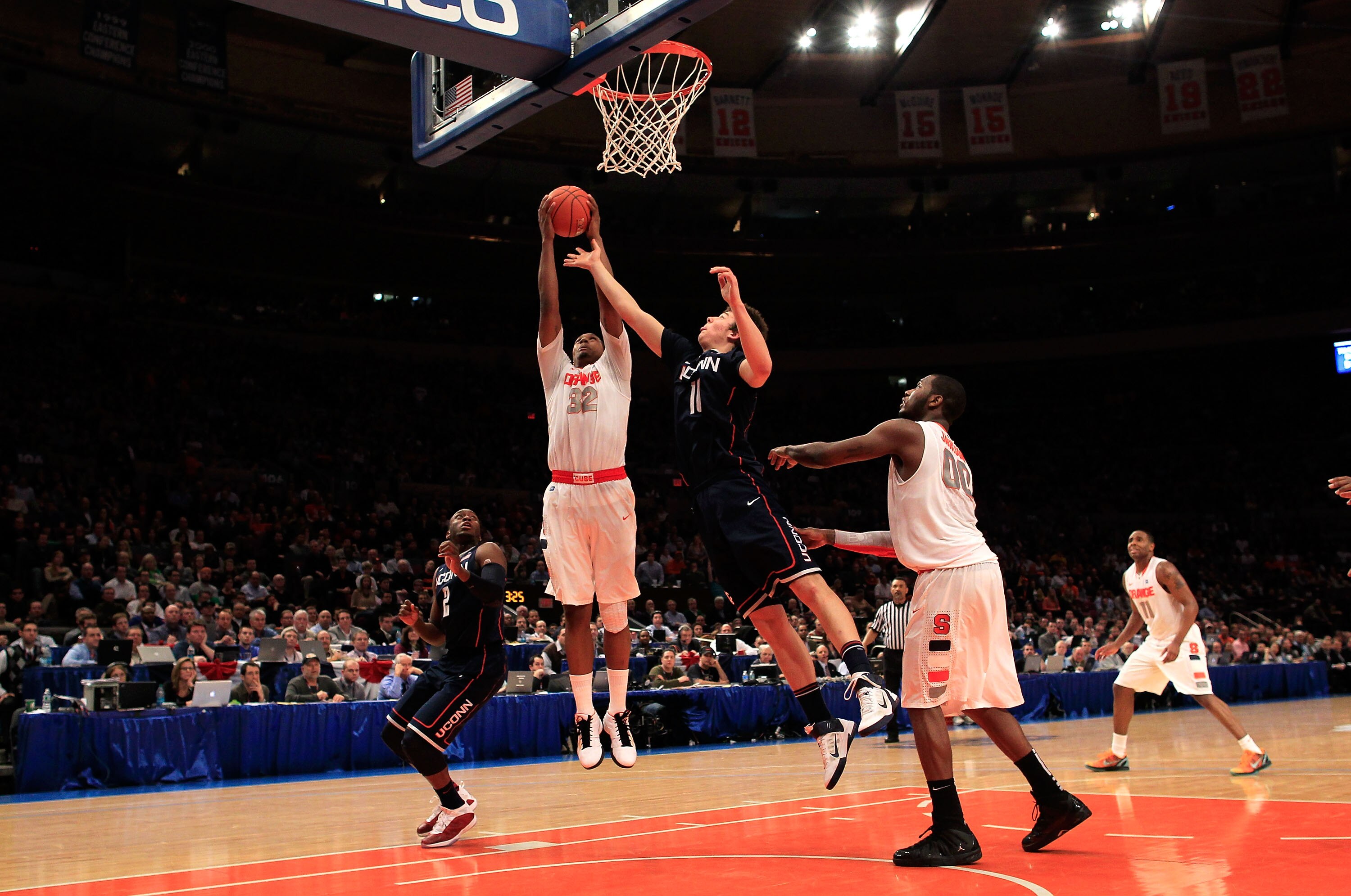 NEW YORK, NY - MARCH 11: Kris Joseph #32 of the Syracuse Orange and Tyler Olander #10 of the Connecticut Huskies go up for a rebound during the semifinals of the 2011 Big East Men's Basketball Tournament presented by American Eagle Outfitters at Madison S