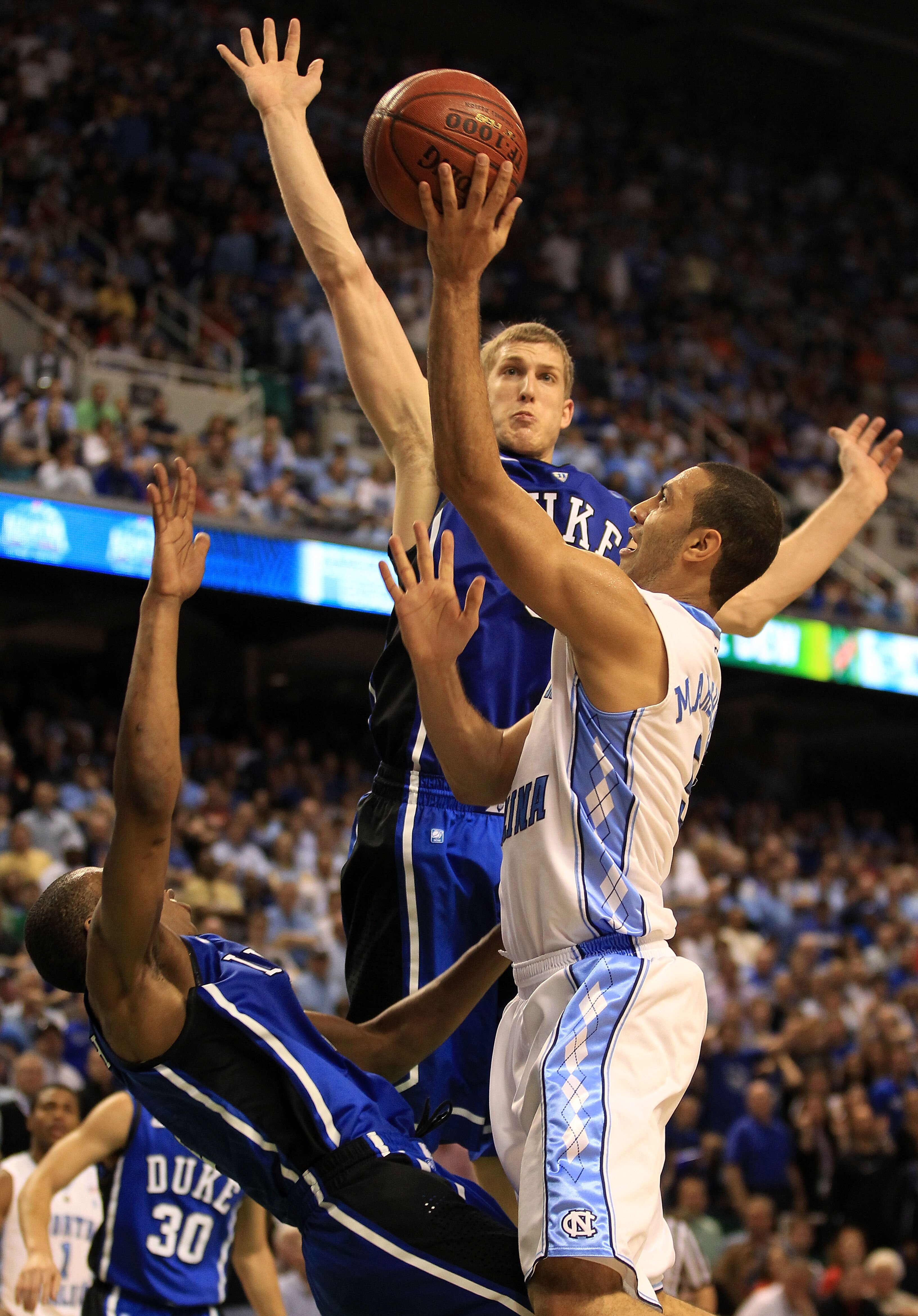 GREENSBORO, NC - MARCH 13:  Kendall Marshall #5 of the North Carolina Tar Heels shoots against Mason Plumlee #5 of the Duke Blue Devils during the second half in the championship game of the 2011 ACC men's basketball tournament at the Greensboro Coliseum