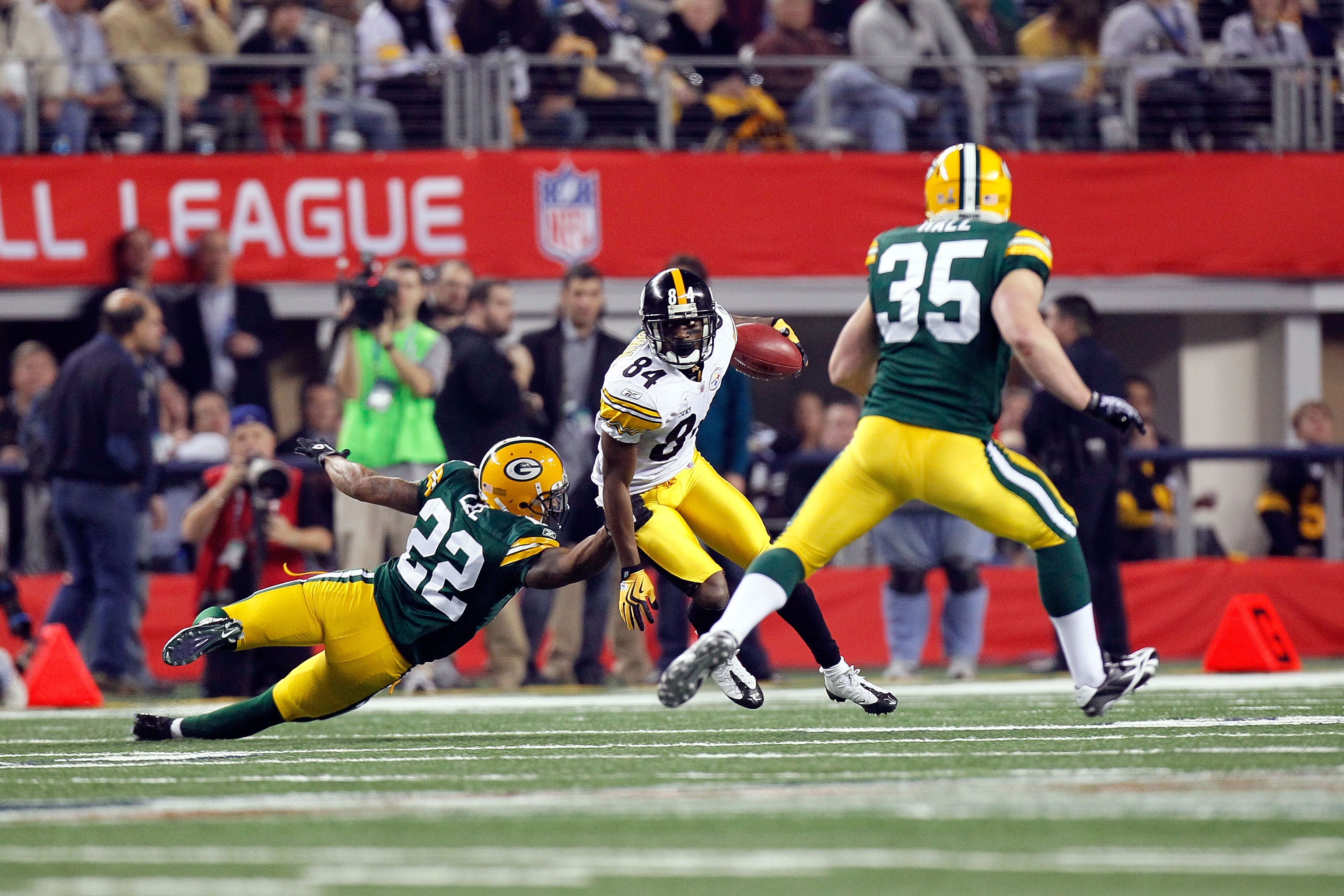 ARLINGTON, TX - FEBRUARY 06:  Antonio Brown #84 of the Pittsburgh Steelers returns a kick against Pat Lee #22 and Korey Hall #35 of the Green Bay Packers during Super Bowl XLV at Cowboys Stadium on February 6, 2011 in Arlington, Texas.  (Photo by Kevin C.