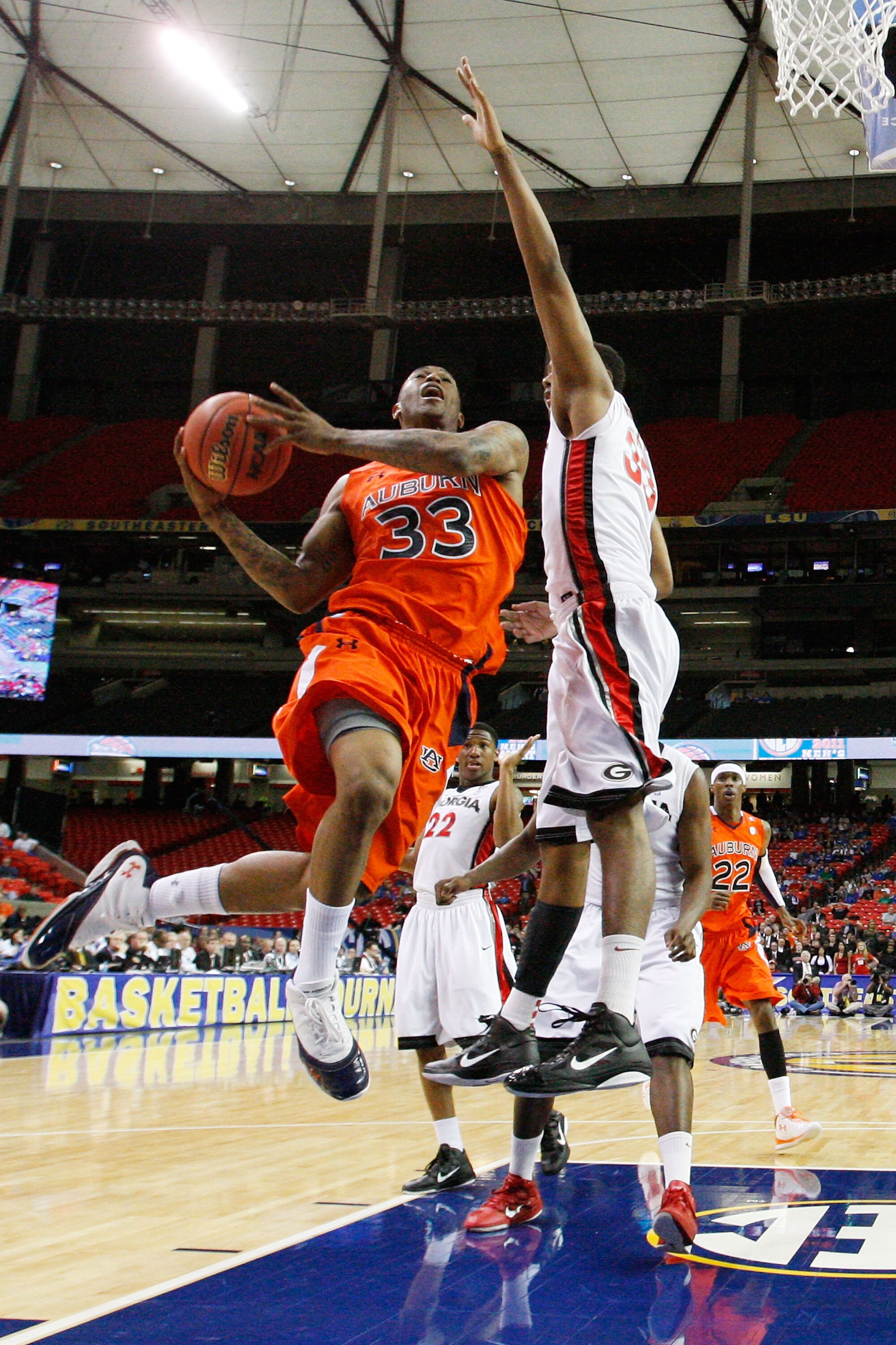 ATLANTA, GA - MARCH 10:  Earnest Ross #33 of the Auburn Tigers shoots against Trey Thompkins #33 of the Georgia Bulldogs during the the first round of the SEC Men's Basketball Tournament at the Georgia Dome on March 10, 2011 in Atlanta, Georgia.  (Photo b