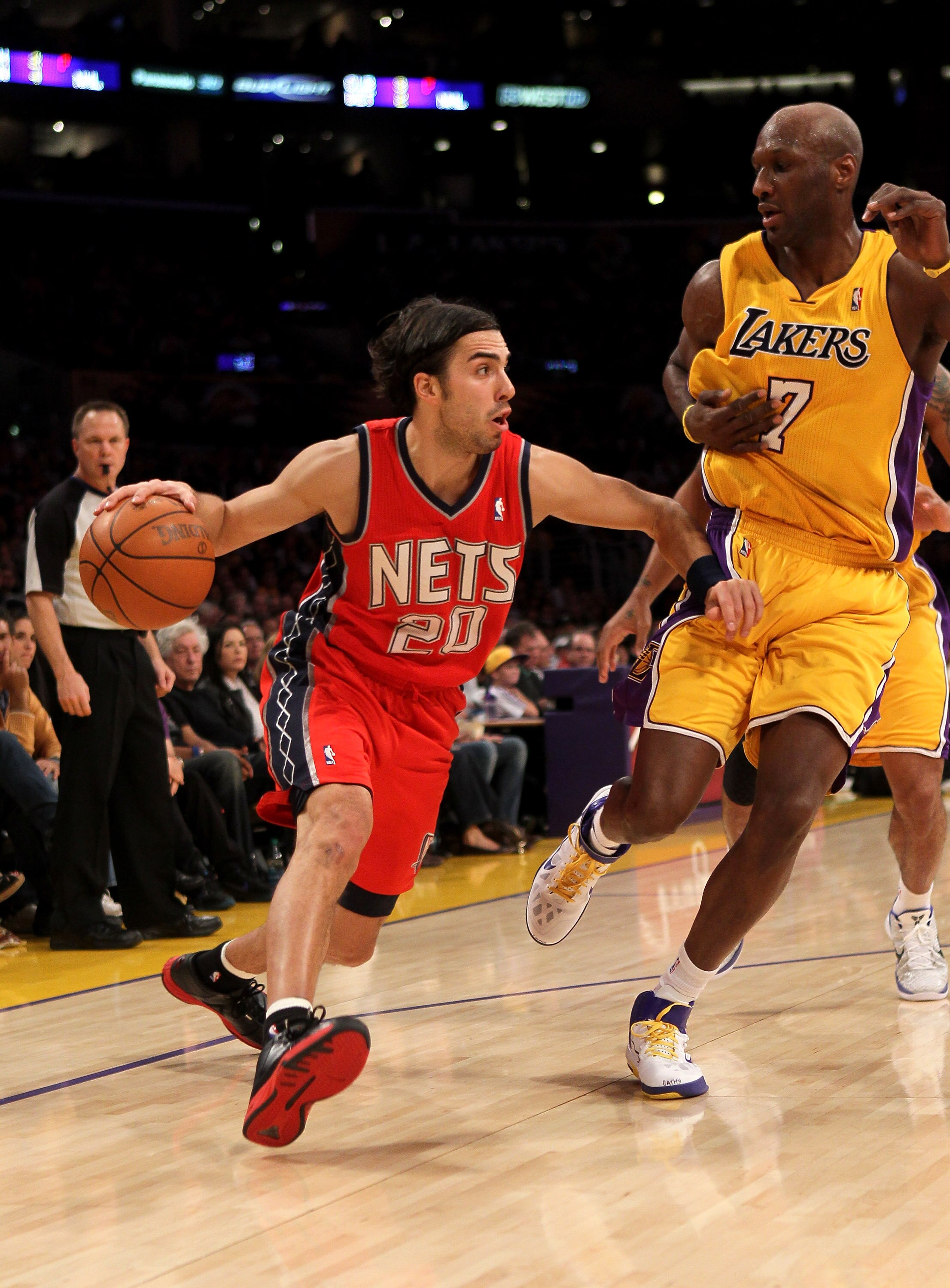 LOS ANGELES, CA - JANUARY 14:  Sasha Vujacic #20 of the New Jersey Nets drives against Lamar Odom #7 of the Los Angeles Lakers at Staples Center on January 14, 2011 in Los Angeles, California. The Lakers won 100-88.  NOTE TO USER: User expressly acknowled