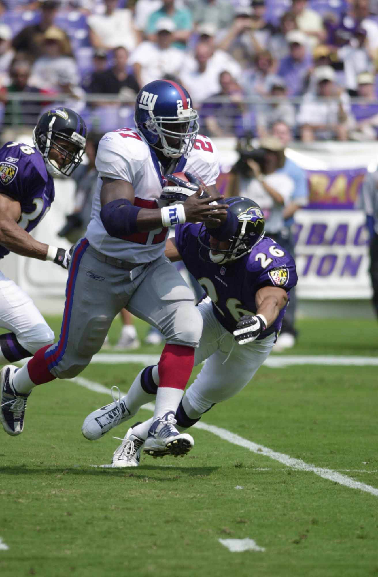31 Aug 2001: Ron Dayne #27 of the New York Giants tries to outrun an attack by Rod Woodson #26 of the Baltimore Ravens during the NFL pre-season game at PSINet Stadium in Baltimore,  Maryland.  The Ravens defeated the Giants 38-9 . DIGITAL IMAGE. Mandator