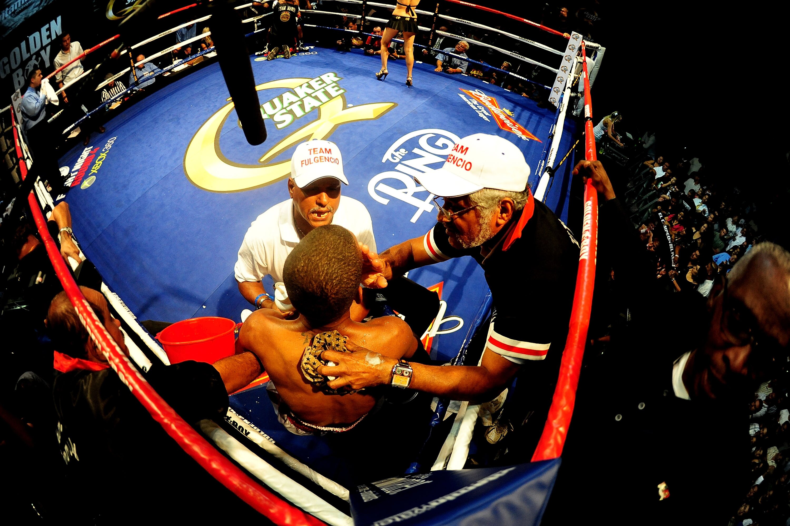 LOS ANGELES - AUGUST 27:  (EDITORS: A FISHEYE LENS WAS USED FOR THIS IMAGE) Carlos Fulgencio of Santo Domingo, DR gets help from his corner as he fights Abner Mares on August 27, 2009 in Los Angeles, California.  (Photo by Jacob de Golish/Getty Images)