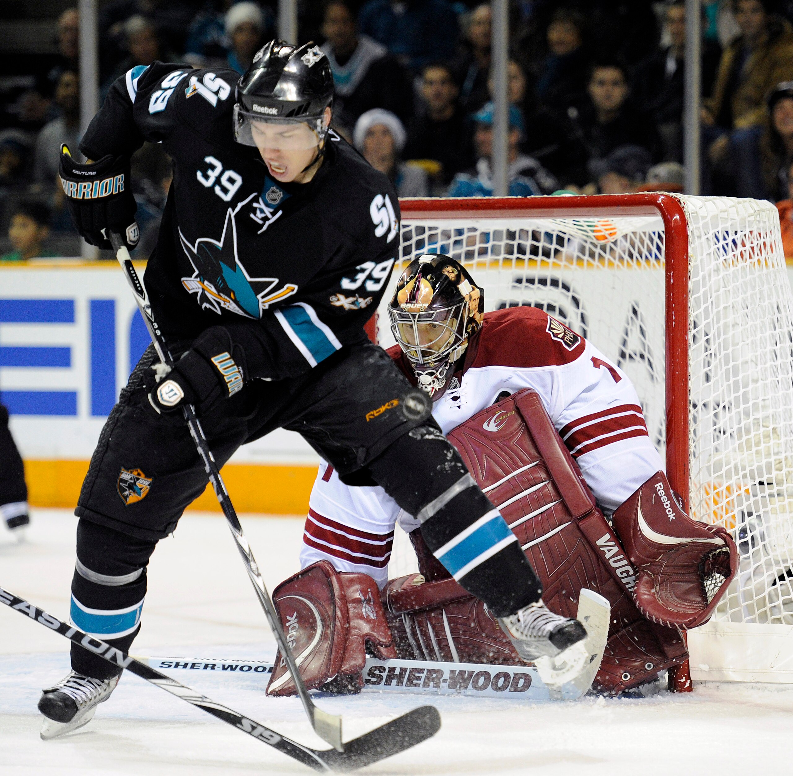 SAN JOSE, CA - DECEMBER 23: Logan Couture #39 of the San Jose Sharks jumps out of the way of the shot on goal as goalie Jason LaBarbera #1of the Phoenix Coyotes makes the save during the 2nd period of an NHL hockey game at the HP Pavilion on December 23,