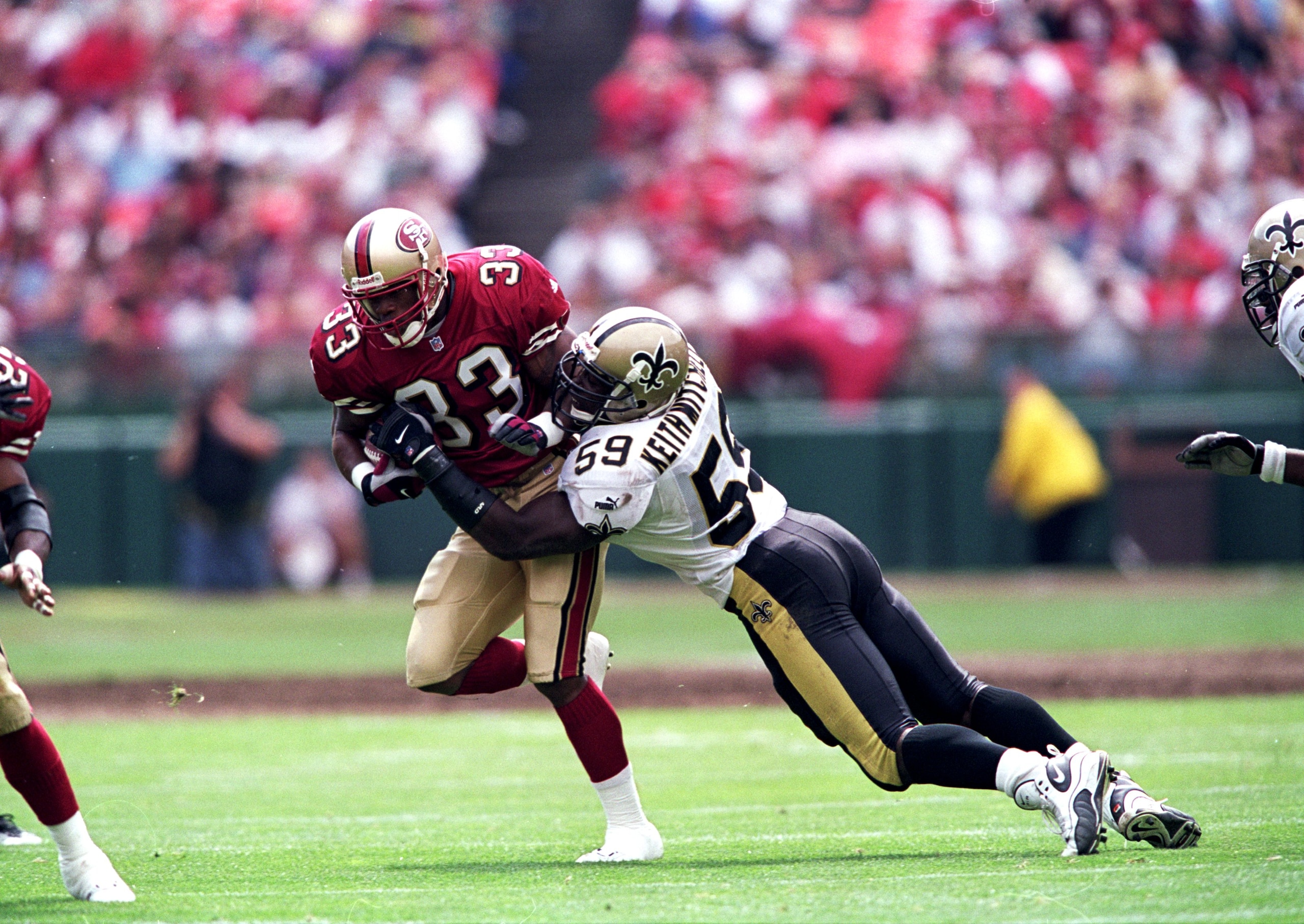 19 Sep 1999:  Lawrence Phillips #33 of the San Francisco 49ers moves with the ball as Keith Mitchell #59 of the New Orleans Saints tries to tackle him during the game at 3 Com Park in San Francisco, California. The 49ers defeated the Saints 28-21. Mandato