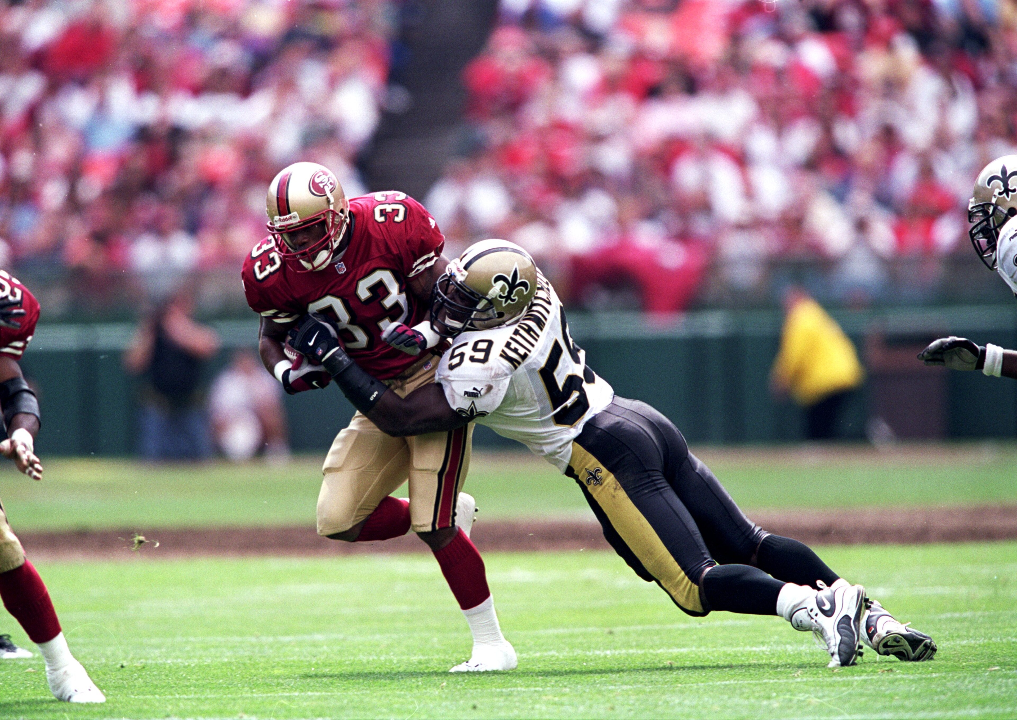 19 Sep 1999:  Lawrence Phillips #33 of the San Francisco 49ers moves with the ball as Keith Mitchell #59 of the New Orleans Saints tries to tackle him during the game at 3 Com Park in San Francisco, California. The 49ers defeated the Saints 28-21. Mandato