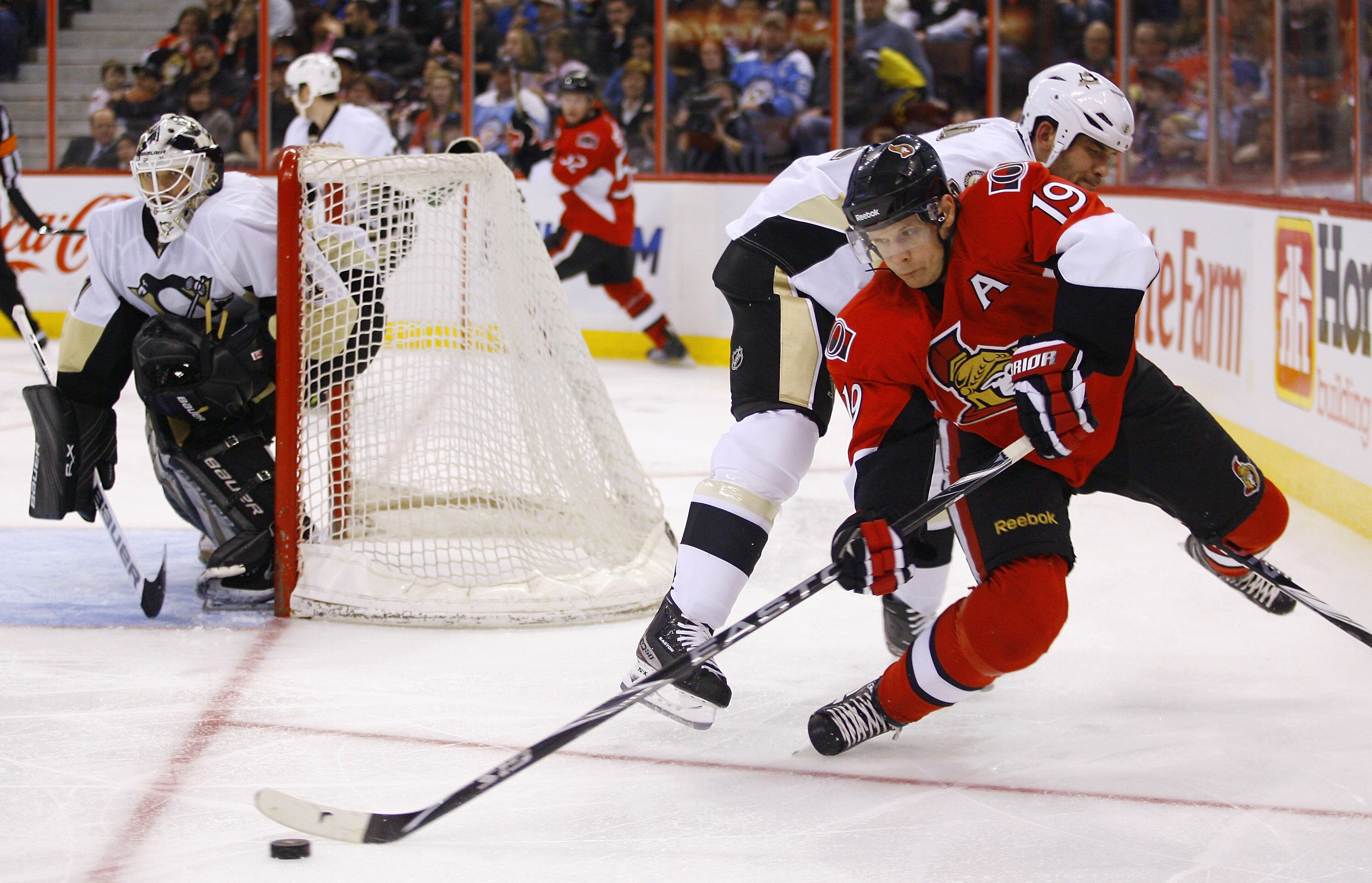 OTTAWA, CANADA - MARCH 15:  Jason Spezza #19 of the Ottawa Senators tries to send a pass to the front of the net while being tripped by Deryk Engelland #5 of the Pittsburgh Penguins during a game at Scotiabank Place on March 15, 2011 in Ottawa, Canada.  (