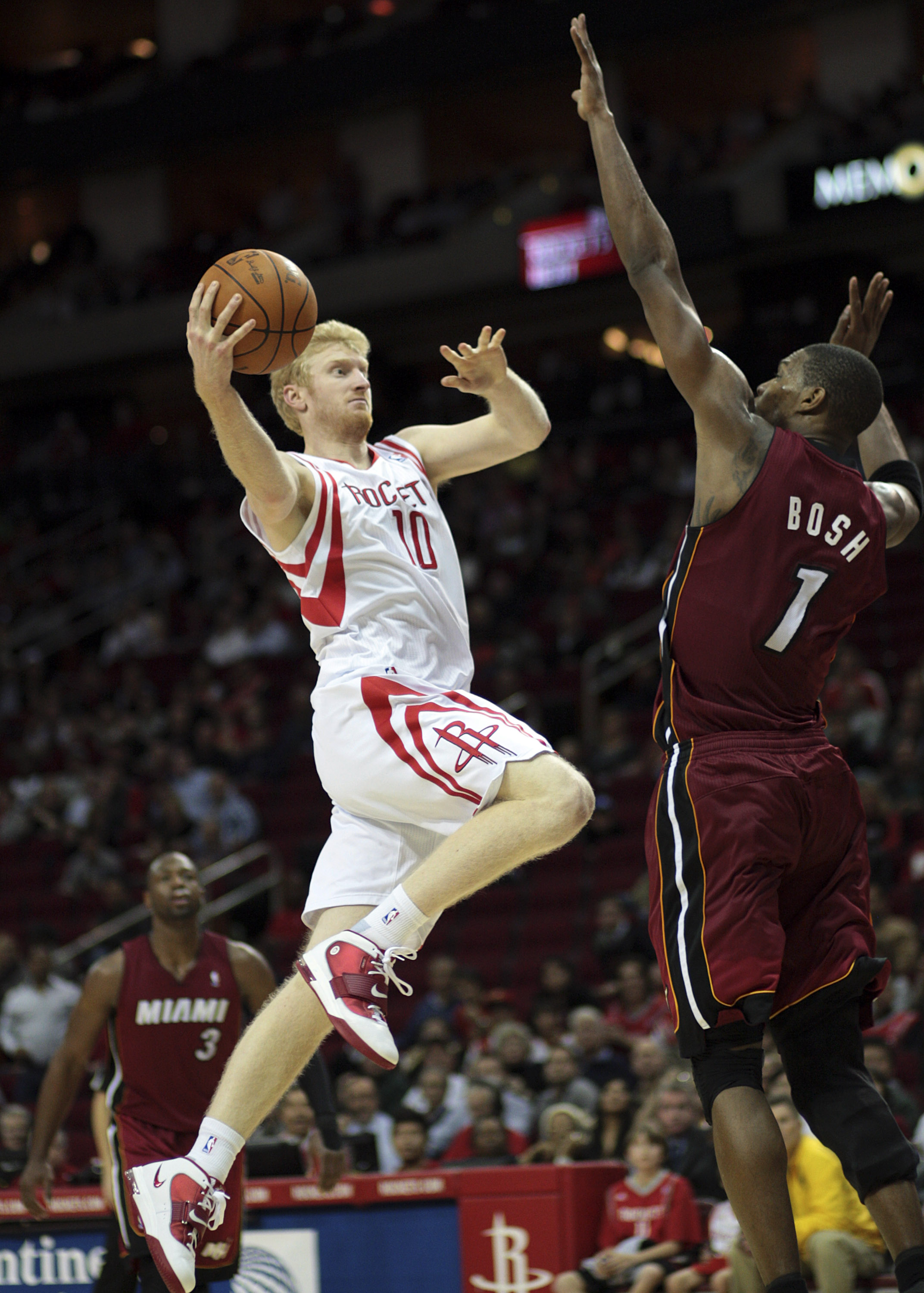 HOUSTON - DECEMBER 29: Chase Budinger #10 of the Houston Rockets drives the basket over Chris Bosh #1 of the Miami Heat in the second half at Toyota Center on December 29, 2010 in Houston, Texas. Miami won 125-119. NOTE TO USER: User expressly acknowledge HOUSTON - DECEMBER 29: Chase Budinger #10 of the Houston Rockets drives the basket over Chris Bosh #1 of the Miami Heat in the second half at Toyota Center on December 29, 2010 in Houston, Texas. Miami won 125-119. NOTE TO USER: User expressly acknowledge