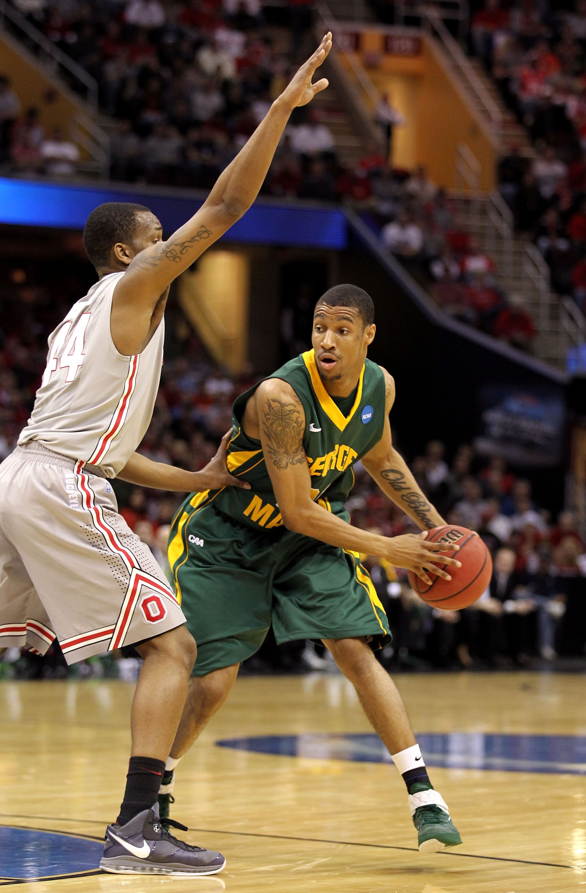 CLEVELAND, OH - MARCH 20: Cam Long #20 of the George Mason Patriots looks to pass against William Buford #44 of the Ohio State Buckeyes during the third of the 2011 NCAA men's basketball tournament at Quicken Loans Arena on March 20, 2011 in Cleveland, Oh
