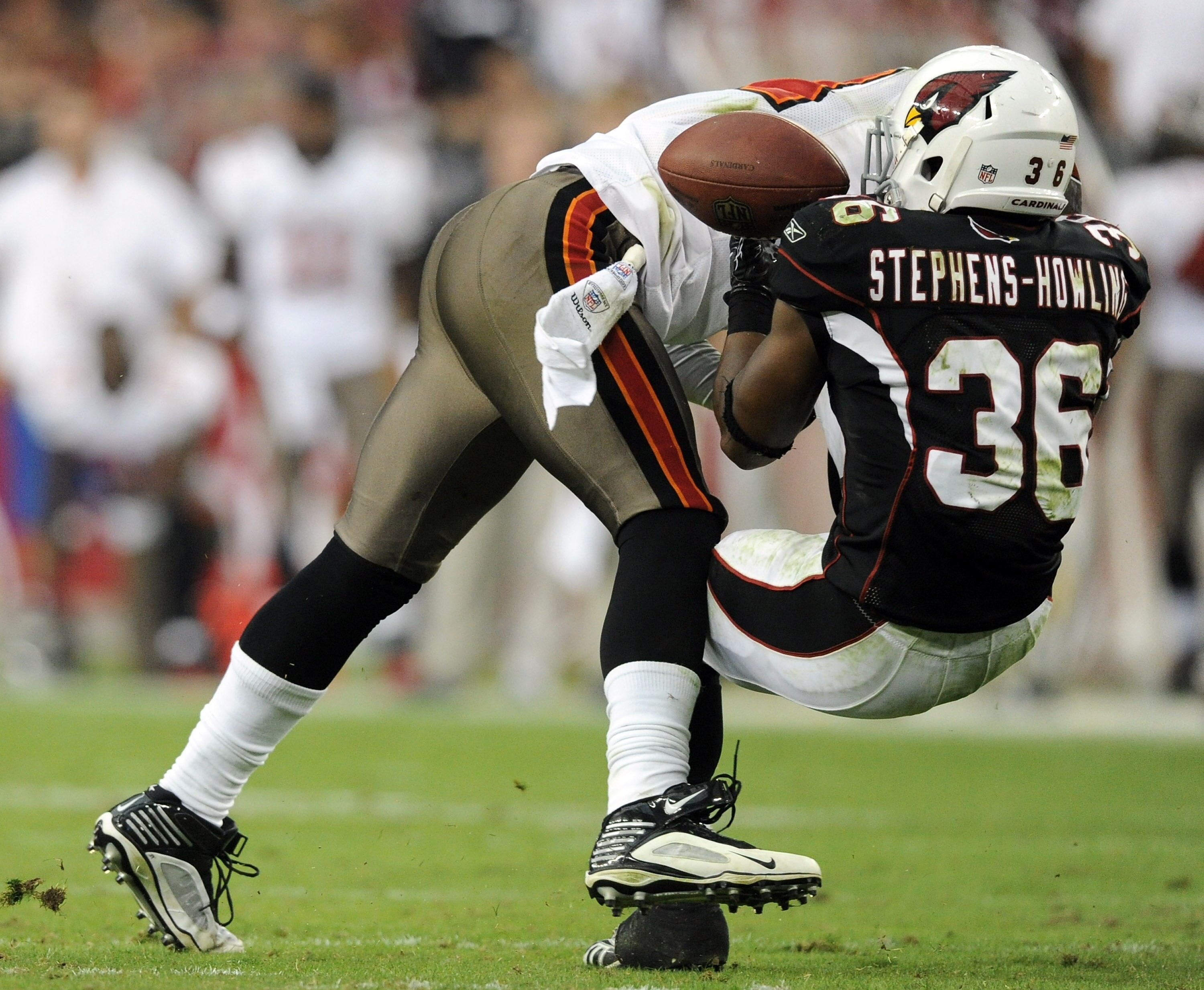 GLENDALE, AZ - OCTOBER 31:  LaRod Stephens-Howling #36 of the Arizona Cardinals takes a hit from Geno Hayes #54 of the Tampa Bay Buccaneers resulting in an interception and injury during the fourth quarter at University of Phoenix Stadium on October 31, 2