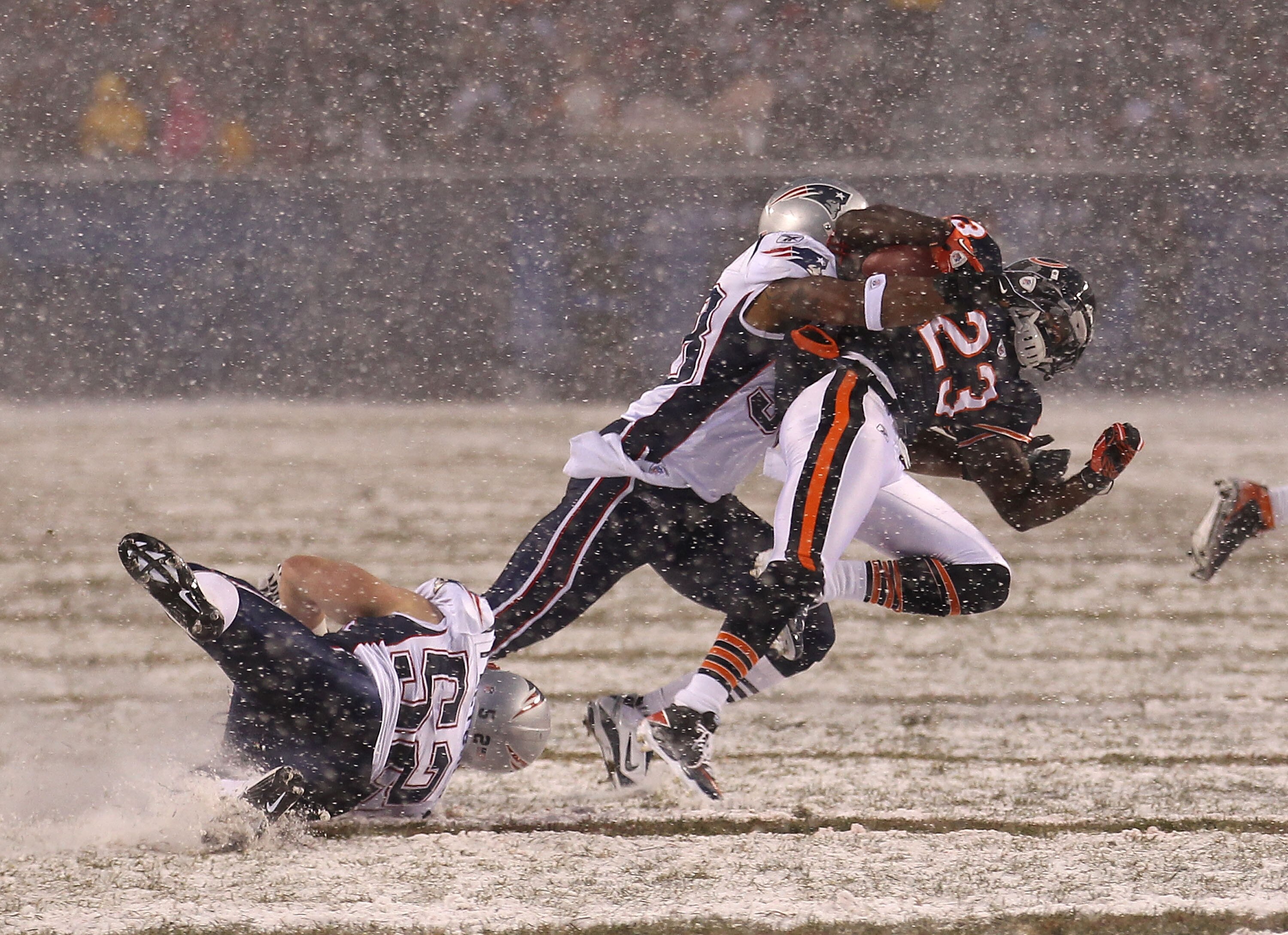 CHICAGO, IL - DECEMBER 12: Devin Hester #23 of the Chicago Bears is tackled by Sergio Brown #38 and Dane Fletcher #52 of the New England Patriots at Soldier Field on December 12, 2010 in Chicago, Illinois. The Patriots defeated the Bears 36-7. (Photo by J