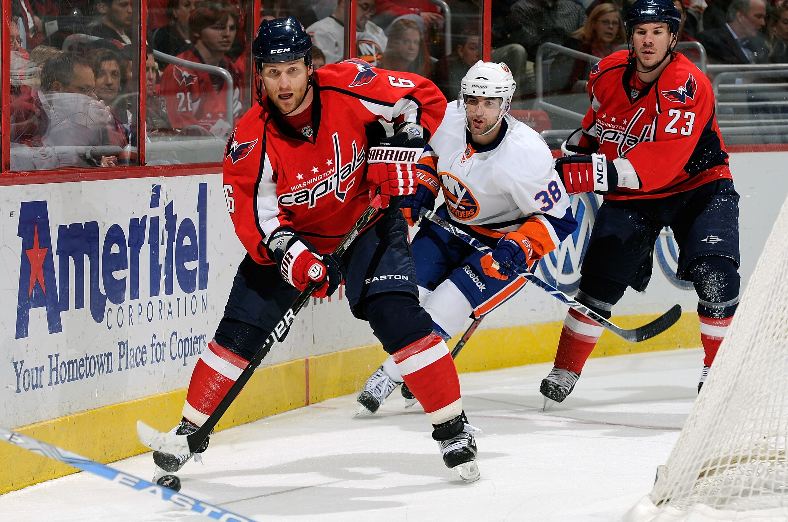 WASHINGTON, DC - MARCH 01:  Dennis Wideman #6 of the Washington Capitals brings the puck around the net against Jack Hillen #38 of the New York Islanders at the Verizon Center on March 1, 2011 in Washington, DC.  (Photo by Greg Fiume/Getty Images)