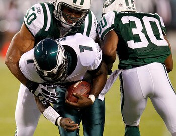 PHILADELPHIA - SEPTEMBER 02:  Michael Vick #7 of the Philadelphia Eagles is tackled by Vernon Gholston #50 and Drew Coleman #30 of the New York Jets during a preseason game at Lincoln Financial Field on September 2, 2010 in Philadelphia, Pennsylvania.  (P