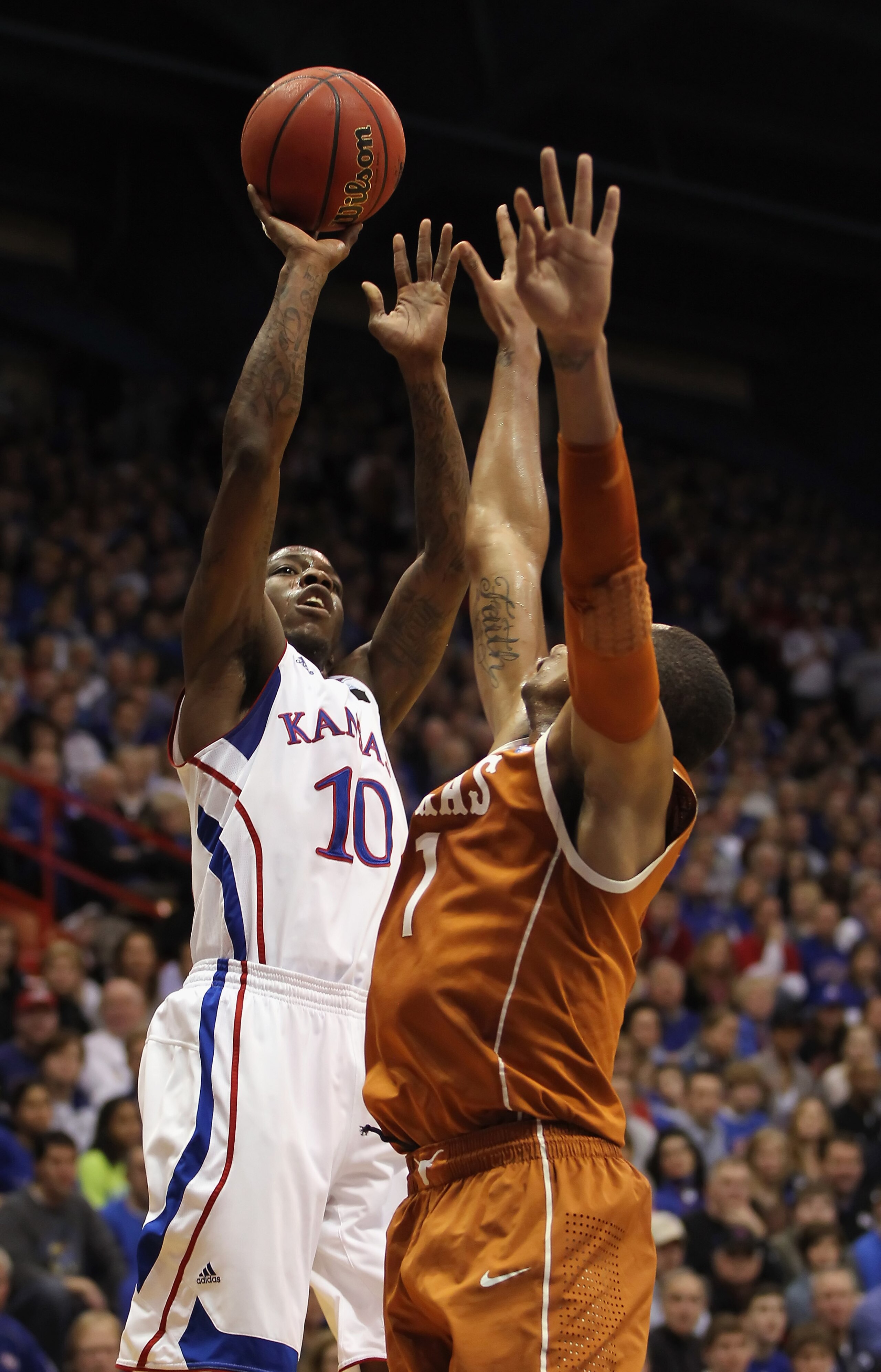 LAWRENCE, KS - JANUARY 22:  Tyshawn Taylor #10 of the Kansas Jayhawks shoots over Gary Johnson #1 of the Texas Longhorns during the game on January 22, 2011 at Allen Fieldhouse in Lawrence, Kansas.  (Photo by Jamie Squire/Getty Images)
