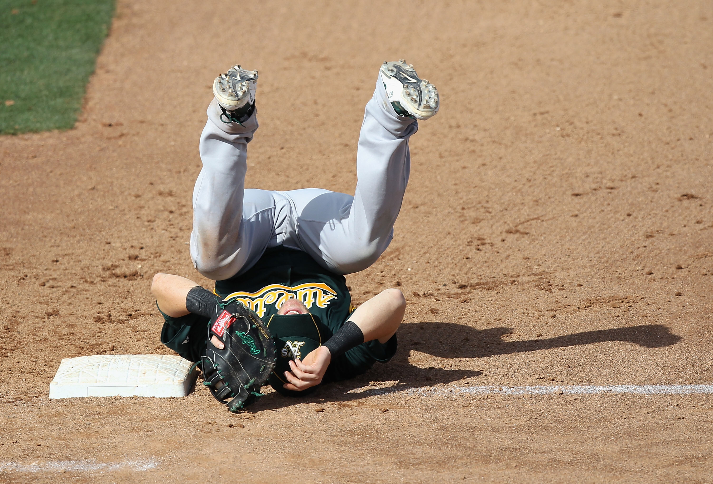 PEORIA, AZ - MARCH 06:  Infielder Daric Barton #10 of the Oakland Athletics lands on his back after a collision with Logan Forsythe (not pictured) of the San Diego Padres during the third inning of the spring training game at Peoria Stadium on March 6, 20