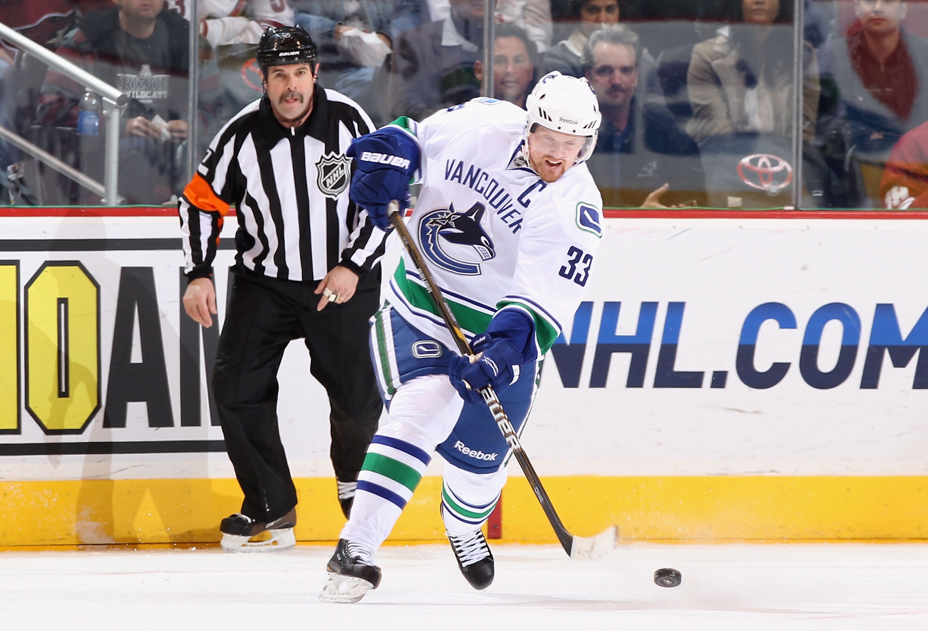 GLENDALE, AZ - FEBRUARY 02:  Henrik Sedin #33 of the Vancouver Canucks clears the puck during the NHL game against the Phoenix Coyotes at Jobing.com Arena on February 2, 2011 in Glendale, Arizona.  The Canucks defeated the Coyotes 6-0.  (Photo by Christia