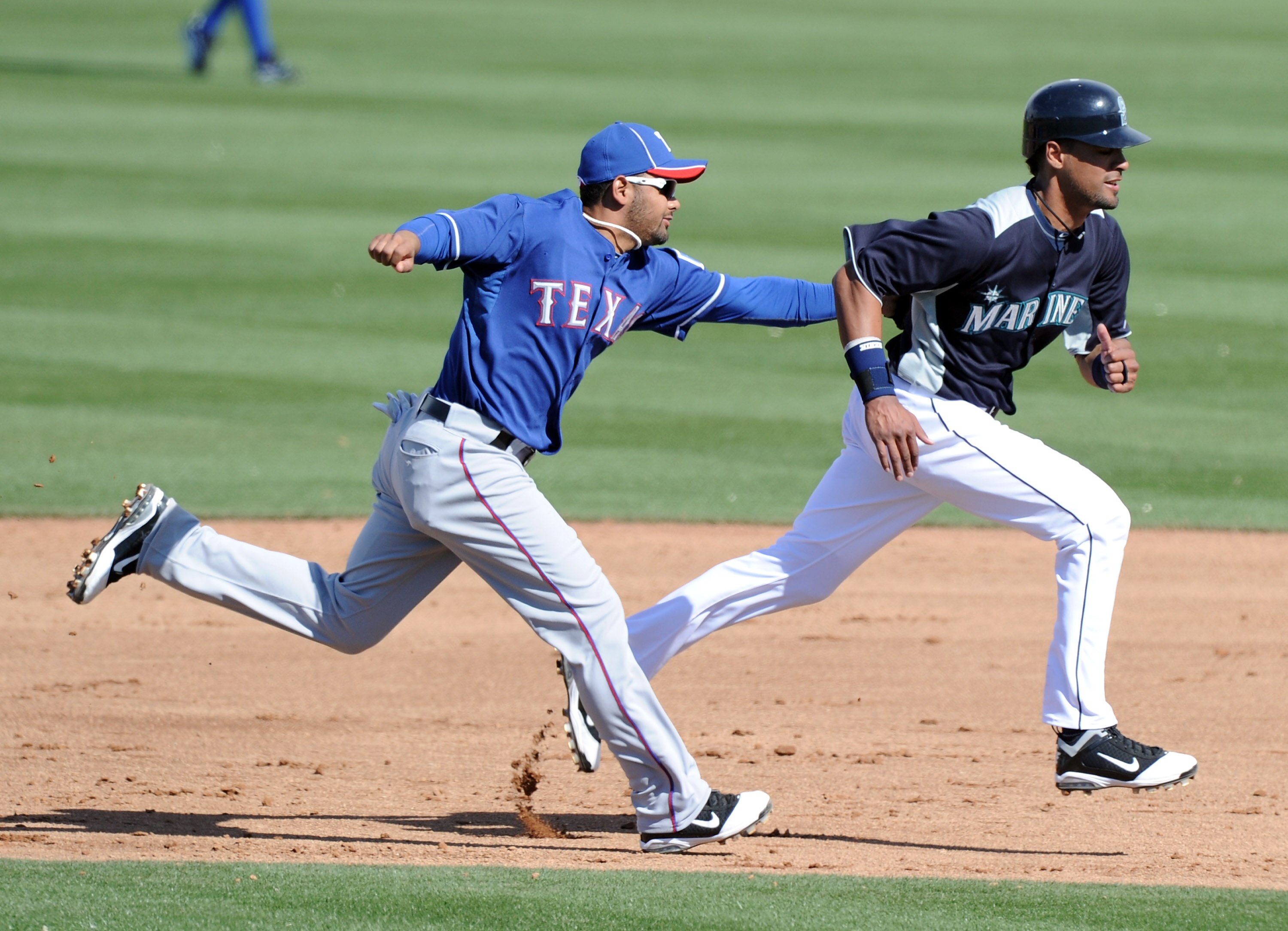 PEORIA, AZ - MARCH 01:  Andres Blanco #3 of the Texas Rangers tags Franklin Gutierrez #21 of the Seattle Mariners for an out during an attempted steal in the sixth inning during spring training at Peoria Stadium on March 1, 2011 in Peoria, Arizona.  (Phot