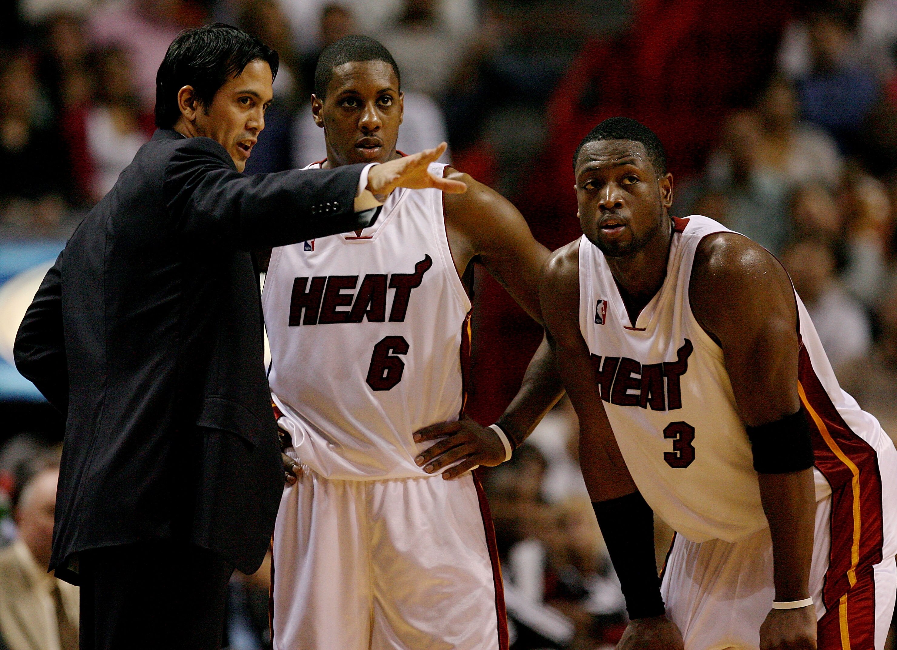 MIAMI - DECEMBER 08:  Head coach Erik Spoelstra talks with Mario Chalmers #6 and Dwyane Wade #3 of the Miami Heat late in fourth-quarter action against the Charlotte Bobcats at American Airlines Arena on December 8, 2008 in Miami, Florida. The Heat defeat
