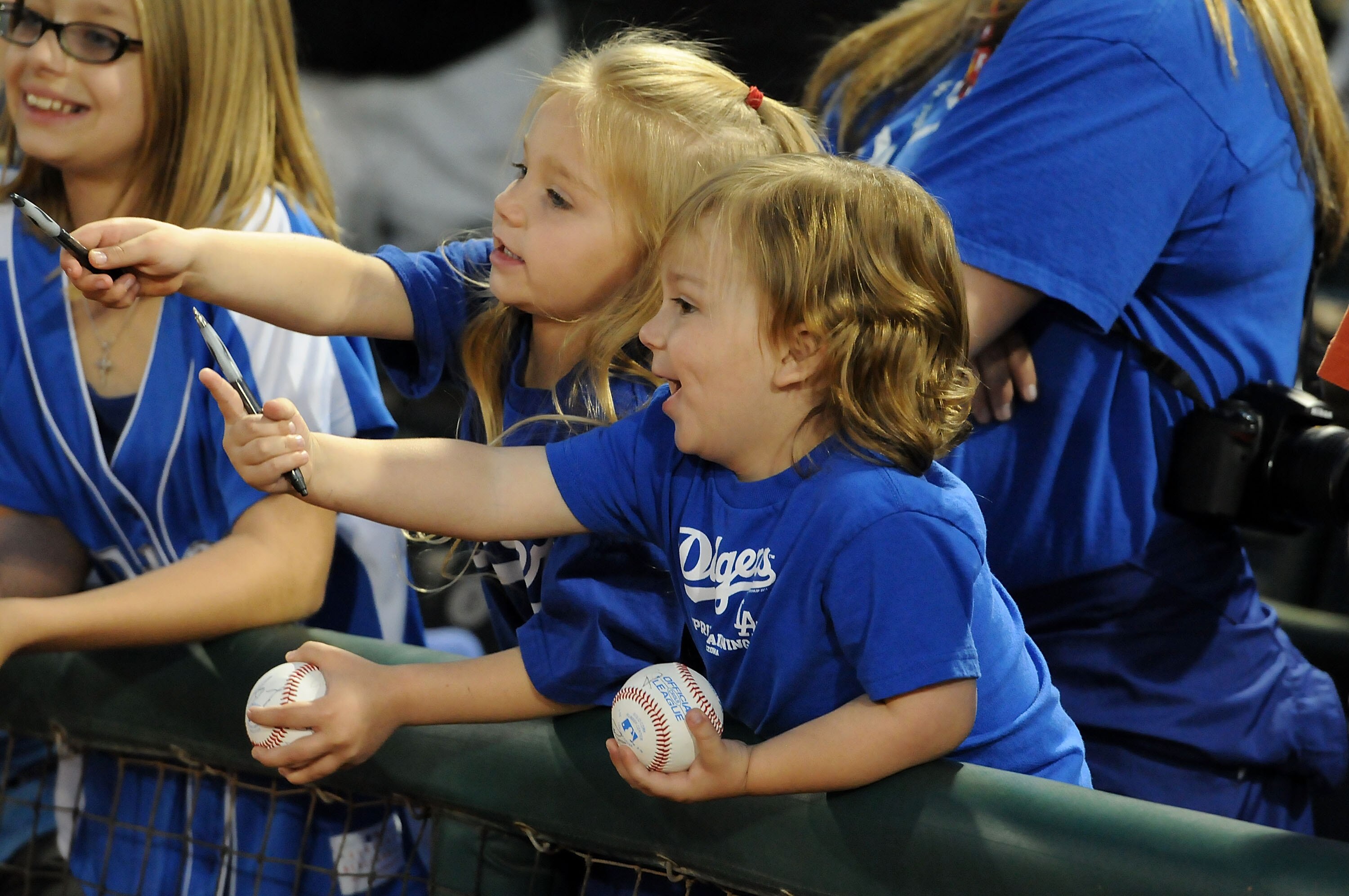 GOODYEAR, AZ - MARCH 03:  Two young Dodger fans try to get autographs prior to the game between the Los Angeles Dodgers and the Cincinnati Reds at Goodyear Ballpark on March 3, 2011 in Goodyear, Arizona.  (Photo by Norm Hall/Getty Images)