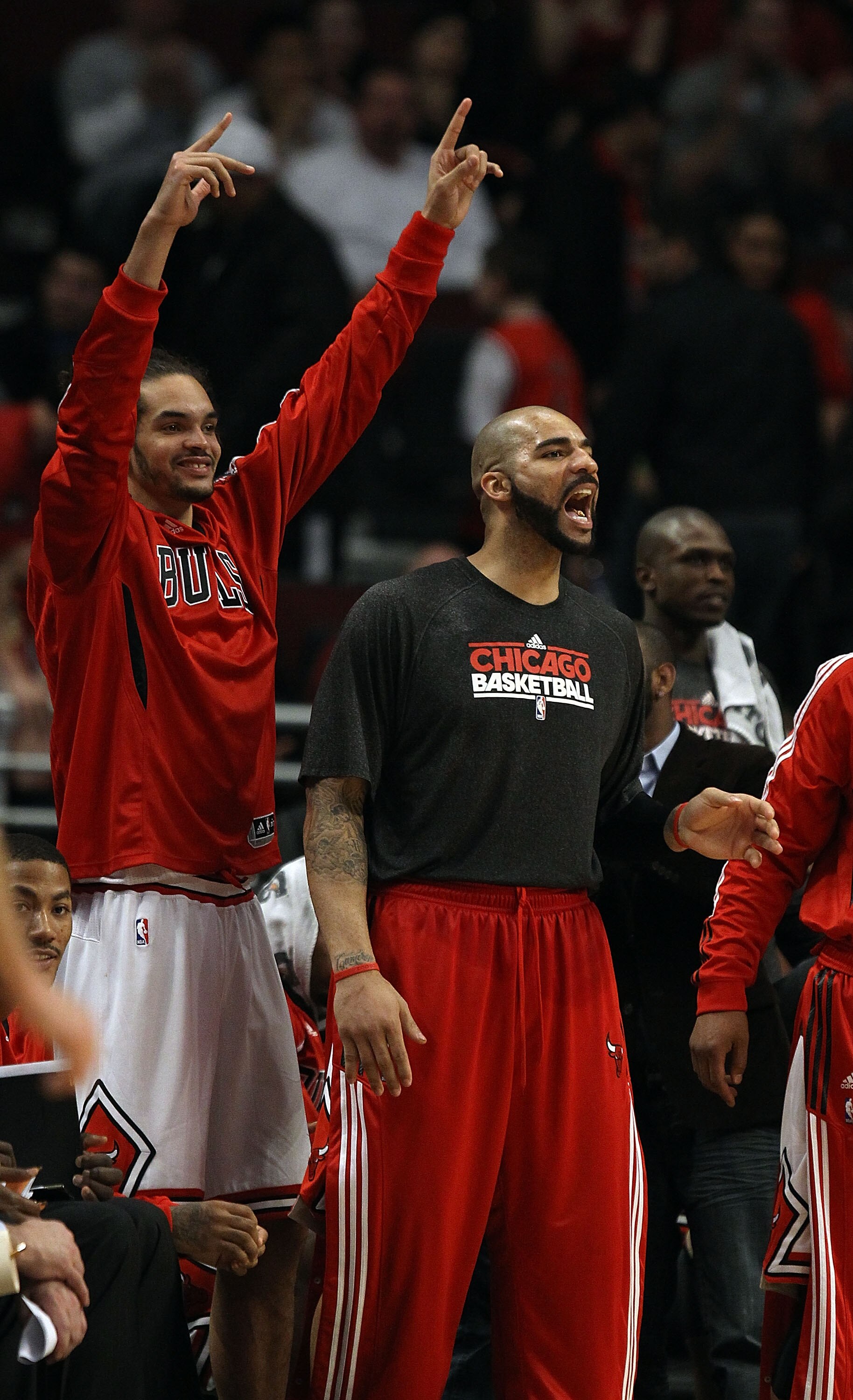 CHICAGO, IL - MARCH 21: Joakim Noah #13 (L) and Carlos Boozer #5 of the Chicago Bulls encourage teammates playing against the Sacramento Kings from the bench at the United Center on March 21, 2011 in Chicago, Illinois. The Bulls defeated the Kings 132-92.