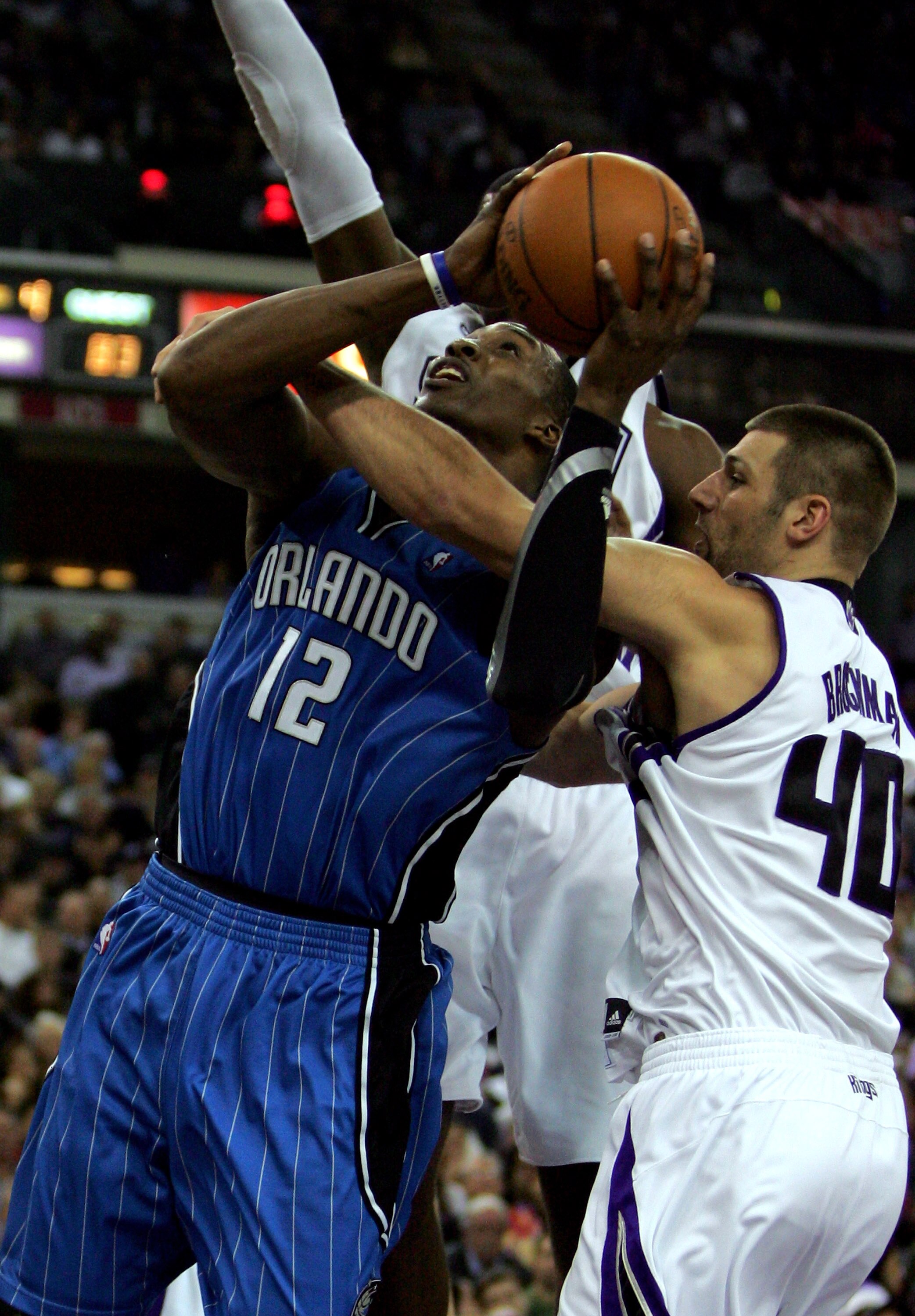 SACRAMENTO, CA - JANUARY 12:  Dwight Howard #12 of the Orlando Magic is fouled by Jon Brockman #40 of the Sacramento Kings at ARCO Arena on January 12, 2010 in Sacramento, California.  NOTE TO USER: User expressly acknowledges and agrees that, by download