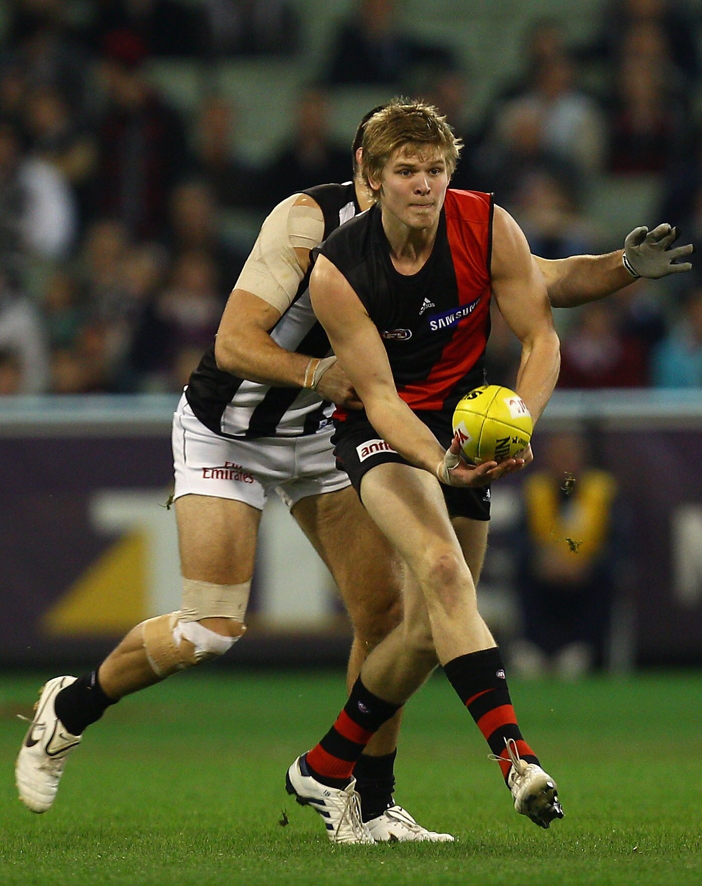 MELBOURNE, AUSTRALIA - AUGUST 13:  Michael Hurley of the Bombers handballs during the round 20 AFL match between the Essendon Bombers and the Collingwood Magpies at Melbourne Cricket Ground on August 13, 2010 in Melbourne, Australia.  (Photo by Quinn Roon