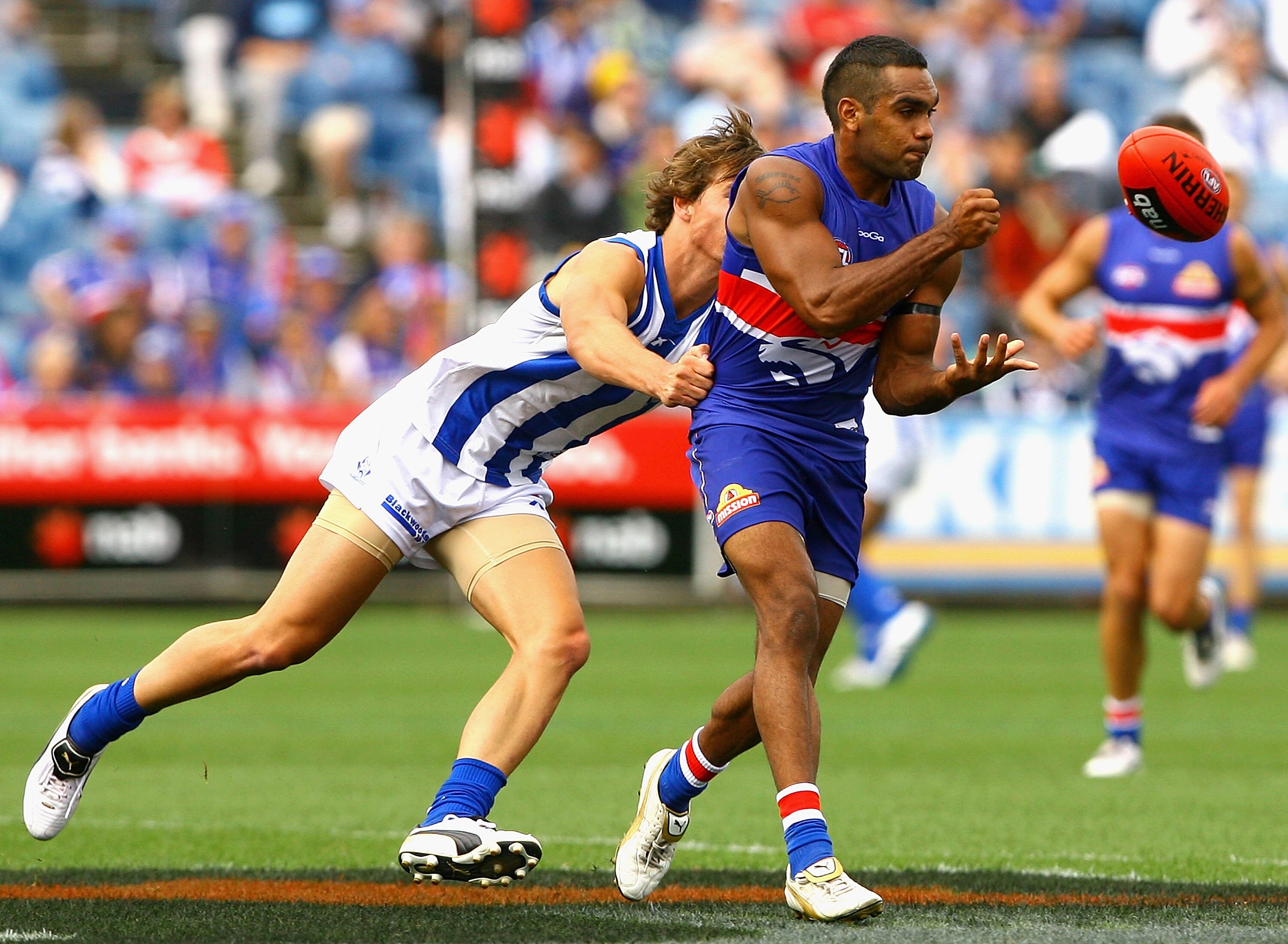 MELBOURNE, AUSTRALIA - FEBRUARY 20:  Nathan Djerrkura of the Bulldogs handballs under pressure during the Pool Six NAB Cup round one AFL match between the North Melbourne Kangaroos and the Western Bulldogs at Skilled Stadium on February 20, 2011 in Melbou