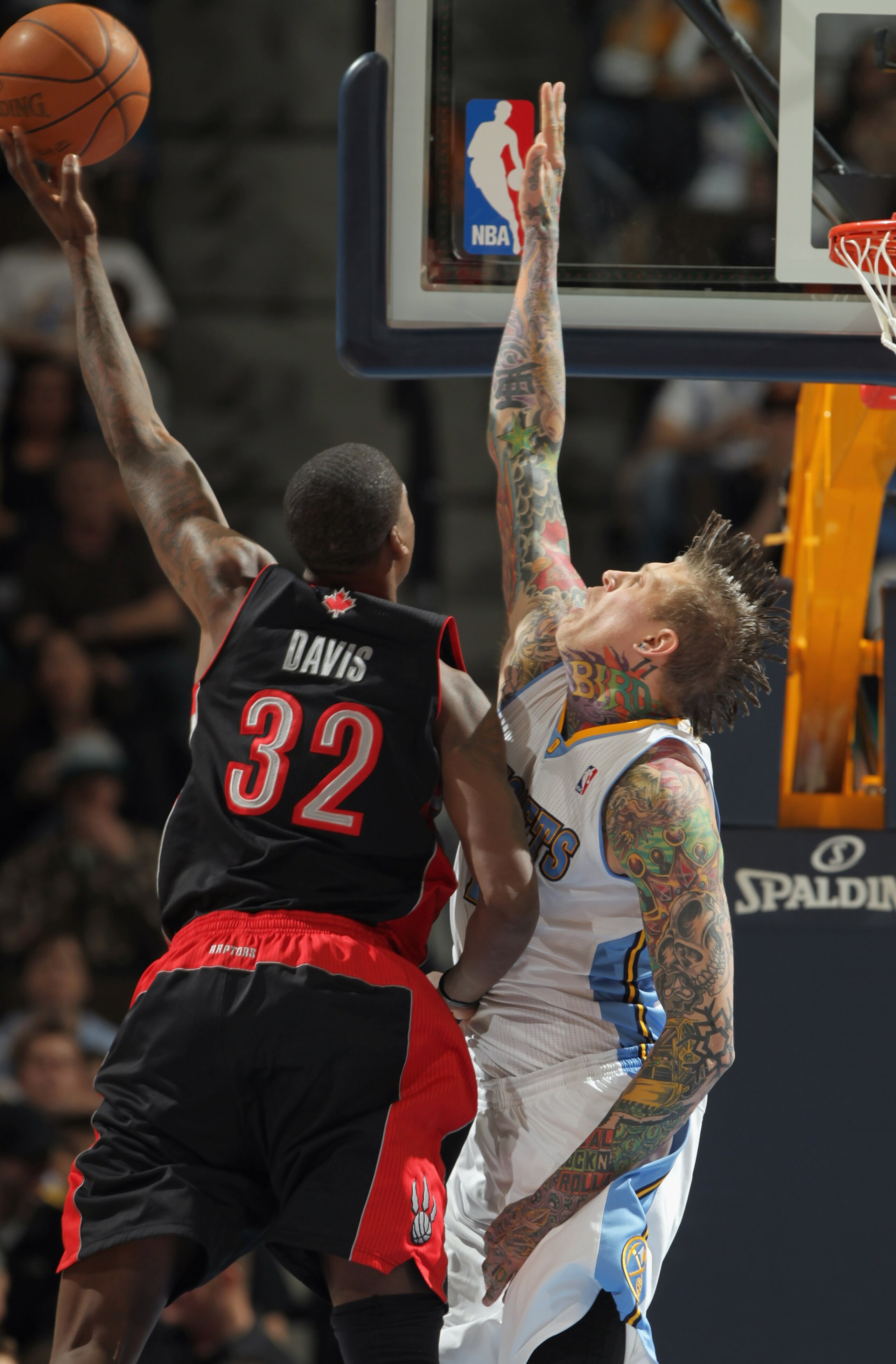 DENVER, CO - MARCH 21:  Chris Andersen #11 of the Denver Nuggets defends against a shot by Ed Davis #32 of the Toronto Raptors at the Pepsi Center on March 21, 2011 in Denver, Colorado. The Nuggets defeated the Raptors 123-90. NOTE TO USER: User expressly