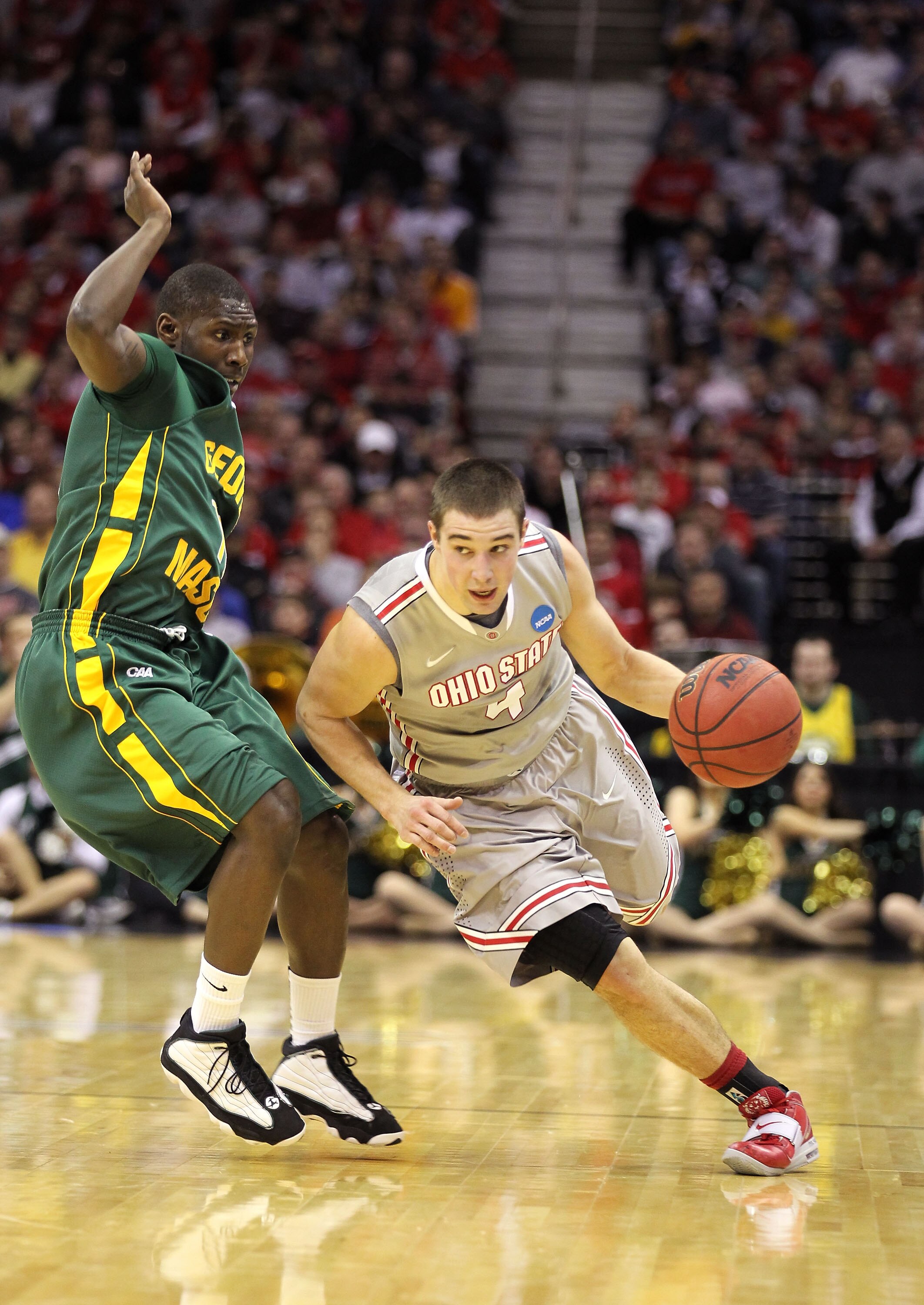 CLEVELAND, OH - MARCH 20: Aaron Craft #4 of the Ohio State Buckeyes dribbles around Vertrail Vaughns #11 of the George Mason Patriots during the third of the 2011 NCAA men's basketball tournament at Quicken Loans Arena on March 20, 2011 in Cleveland, Ohio